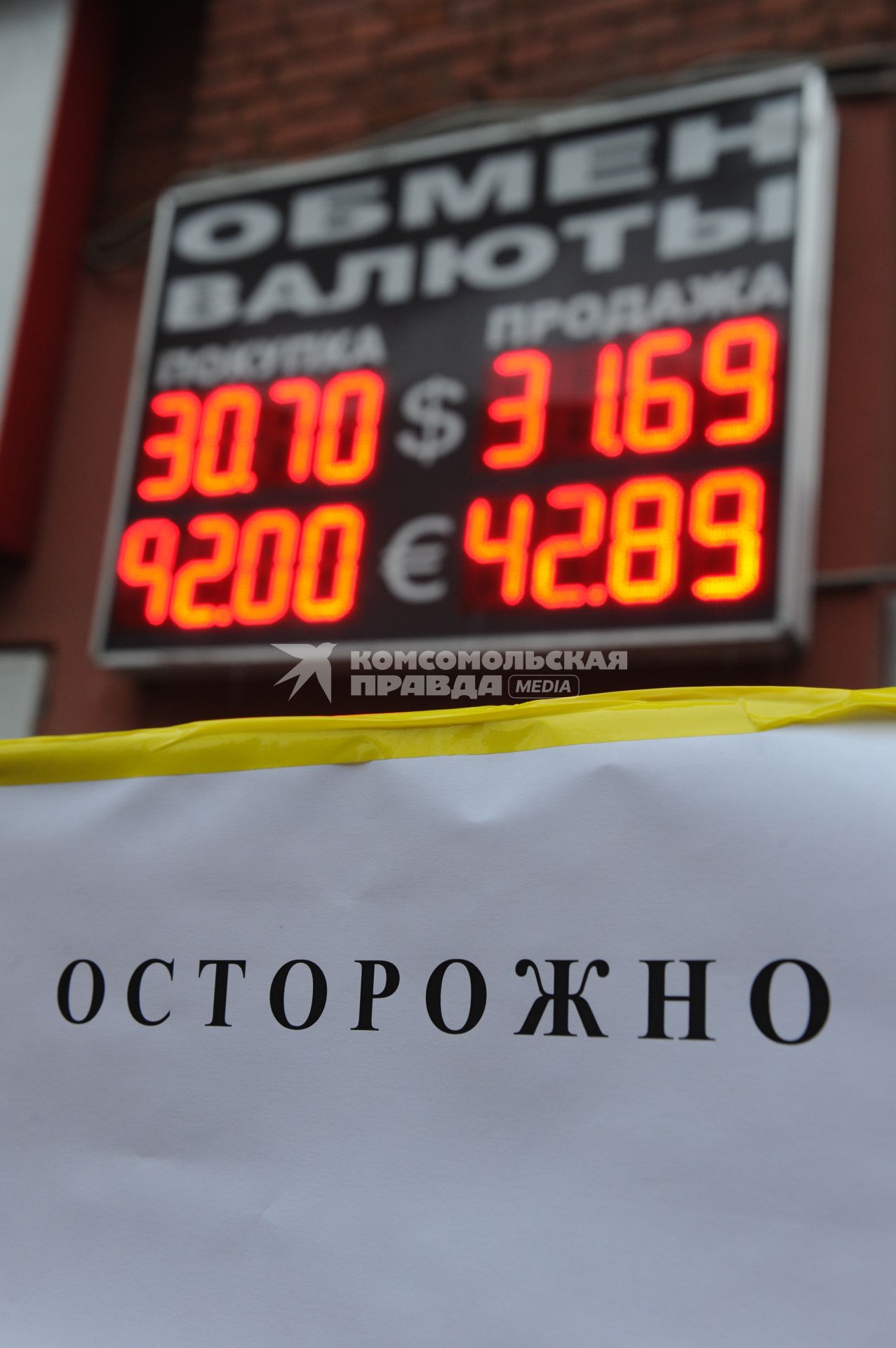 Табло обменного пункта на фоне вывески \"Осторожно!\"
23 ноября 2010.