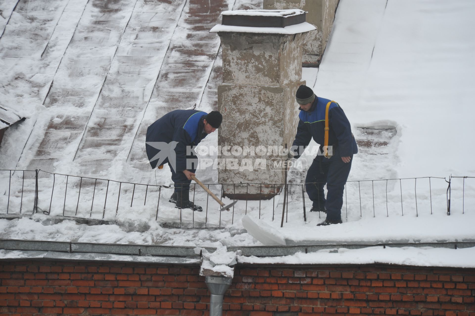 г. Москва.  Гастарбайтеры убирают снег с крыши многоэтажного дома 20 января 2011