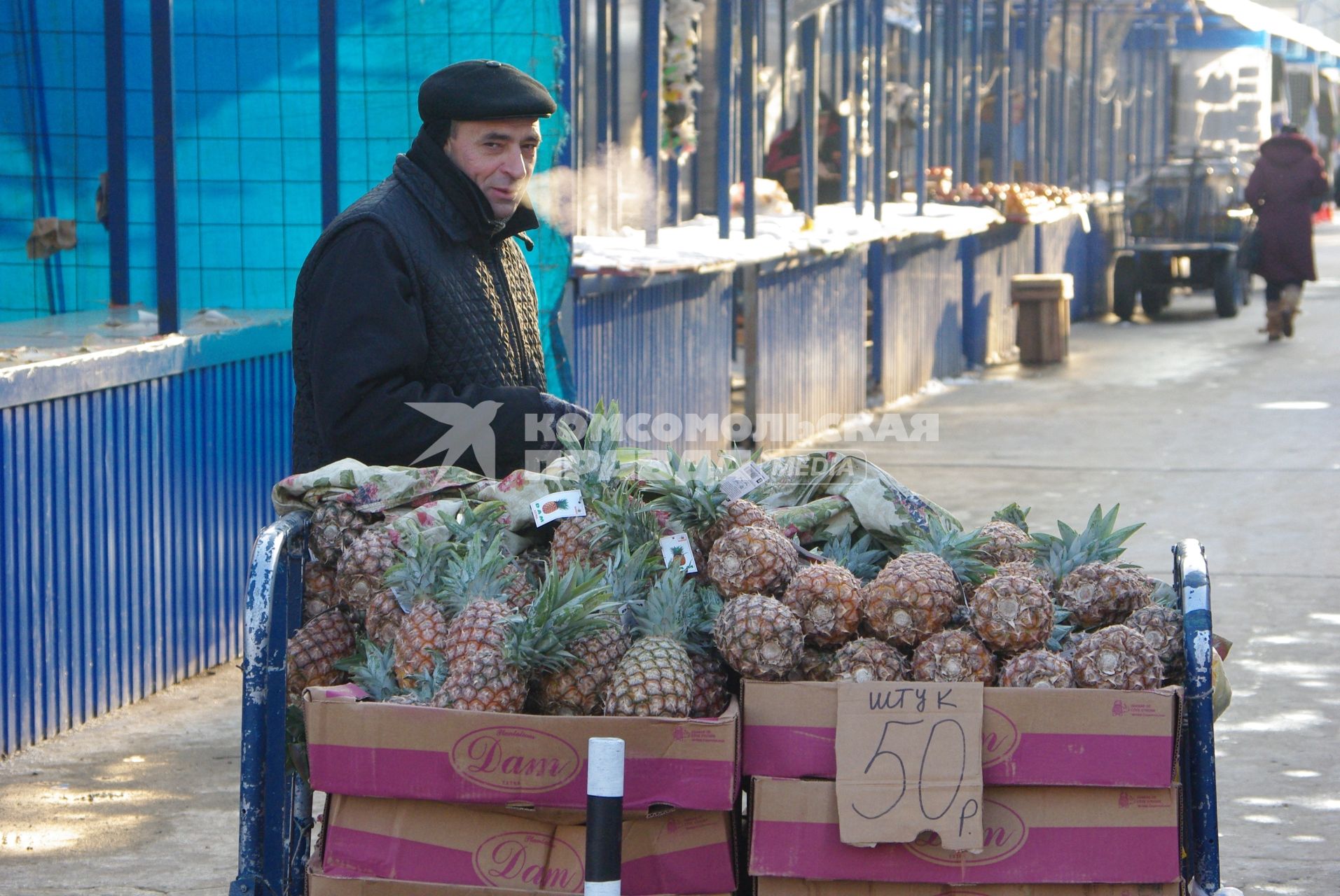 Мужчина неславянской внешности продает на рынке ананасы, на табличке надпись \"Штук- 50 рублей\", Саратов, 20 января 2011 года. Зима, рынок, продажа, ананас, гастарбайтер, нелегал, нелегальная торговля, уличная торговля, отсутствие сертификатов, качество, сертификация.