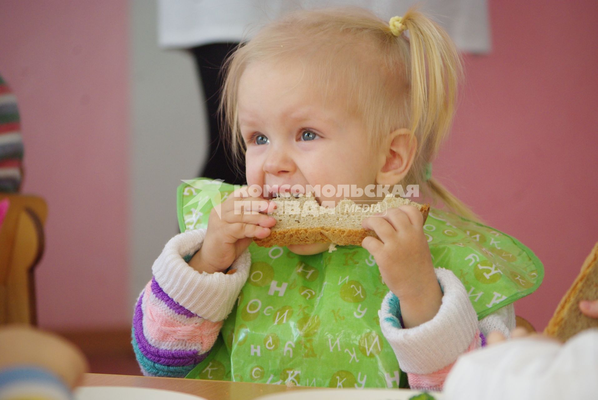 Девочка в детском саду ест хлеб, Саратов, 3 февраля 2011 года. Детский сад, детсад, дети, еда, хлеб, обед, питание, ребенок