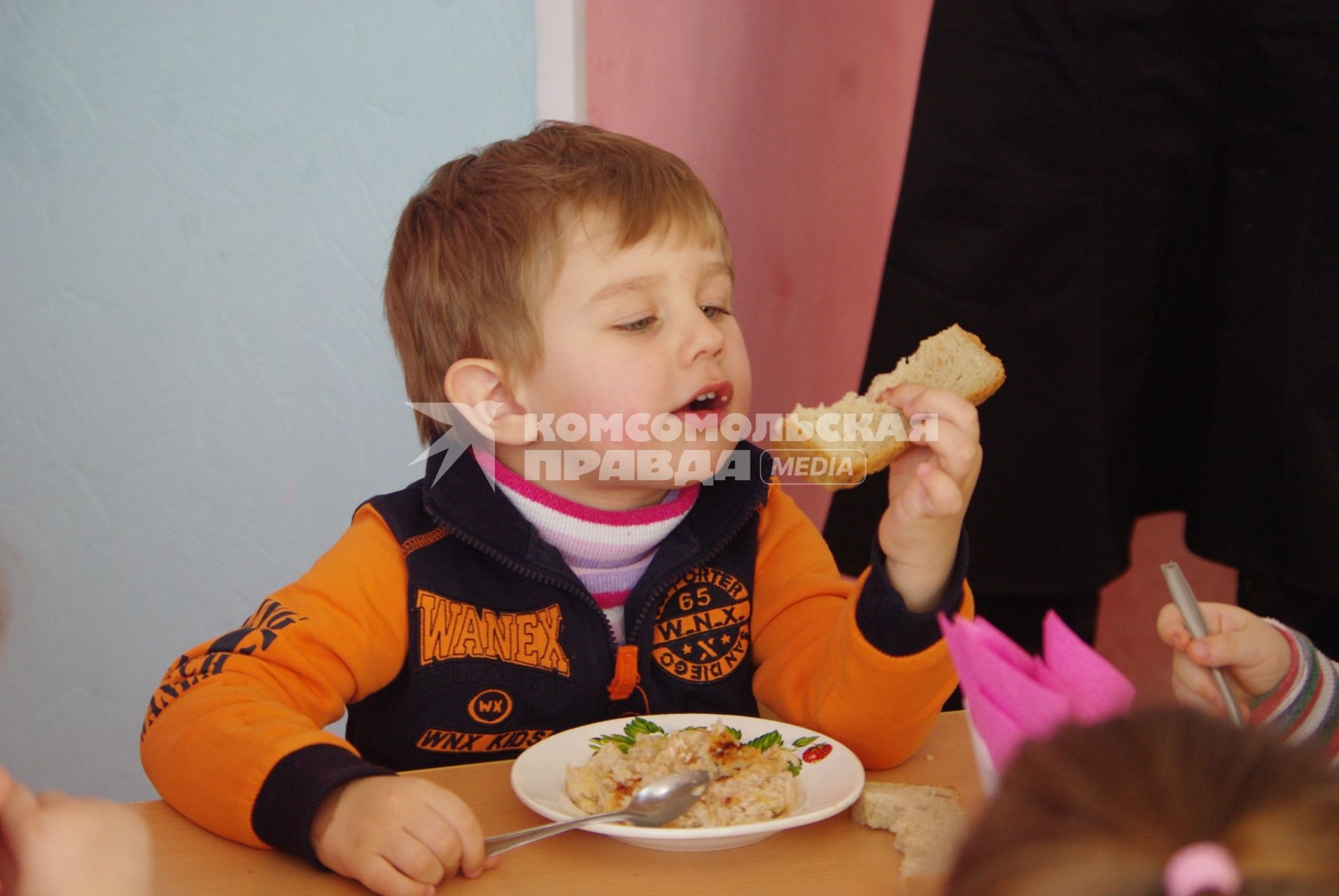 Мальчик в детском садуест хлеб и кашу с котлетой, Саратов, 3 февраля 2011 года. Детский сад, детсад, дети, еда, хлеб, обед, питание, ребенок,каша, котлета
