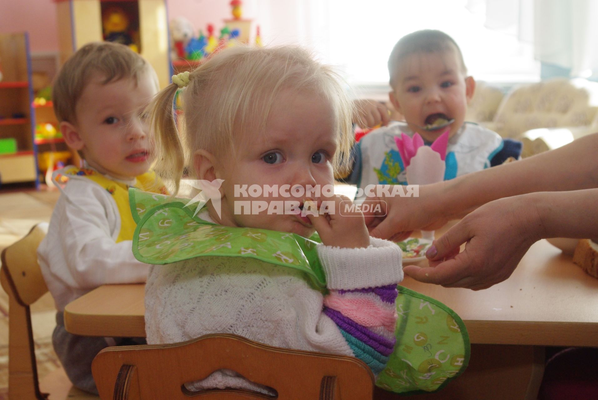 Девочку кормят из ложки в детском саду, Саратов, 3 февраля 2011 года. Детский сад, детсад, дети, еда, хлеб, обед, питание, ребенок, суп,