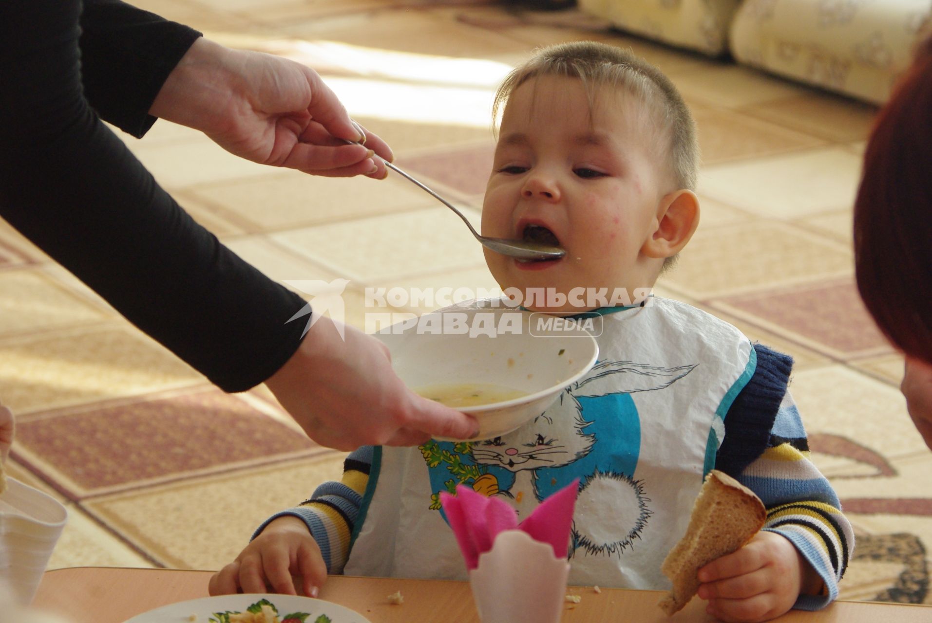 Мальчика кормят из ложки в детском саду, Саратов, 3 февраля 2011 года. Детский сад, детсад, дети, еда, хлеб, обед, питание, ребенок, суп,