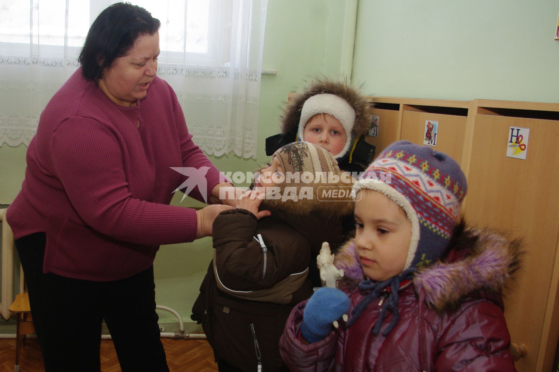 Дети в раздевалке детского сада переодеваются- собираются на прогулку, Саратов, 3 февраля 2011 года. Дети, детсад, детский сад, прогулка, одежда, зима, группа, воспитатель