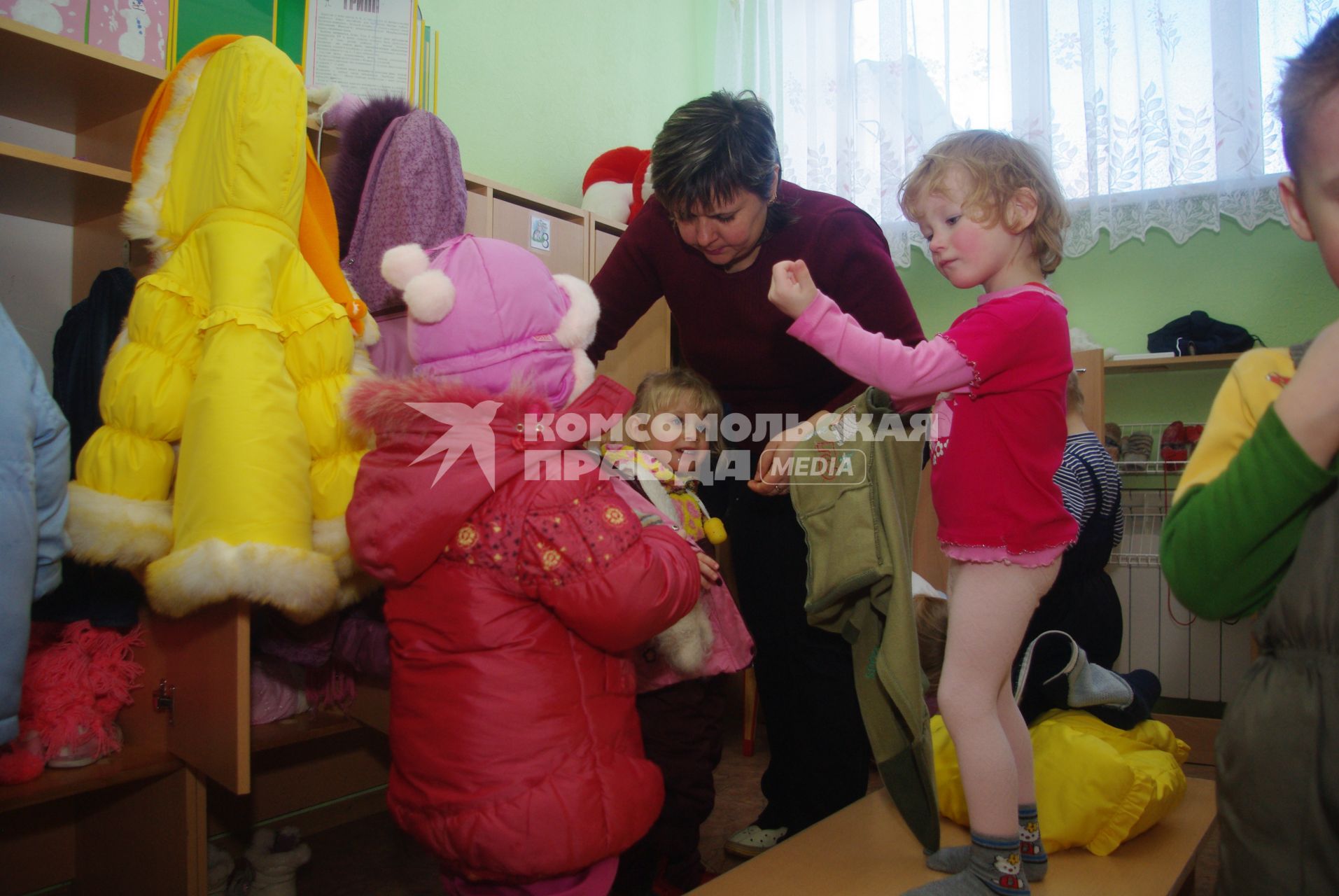 Дети в раздевалке детского сада переодеваются после прогулки на свежем воздухе, Саратов, 3 февраля 2011 года. Дети, детсад, детский сад, прогулка, одежда, зима, группа, воспитатель