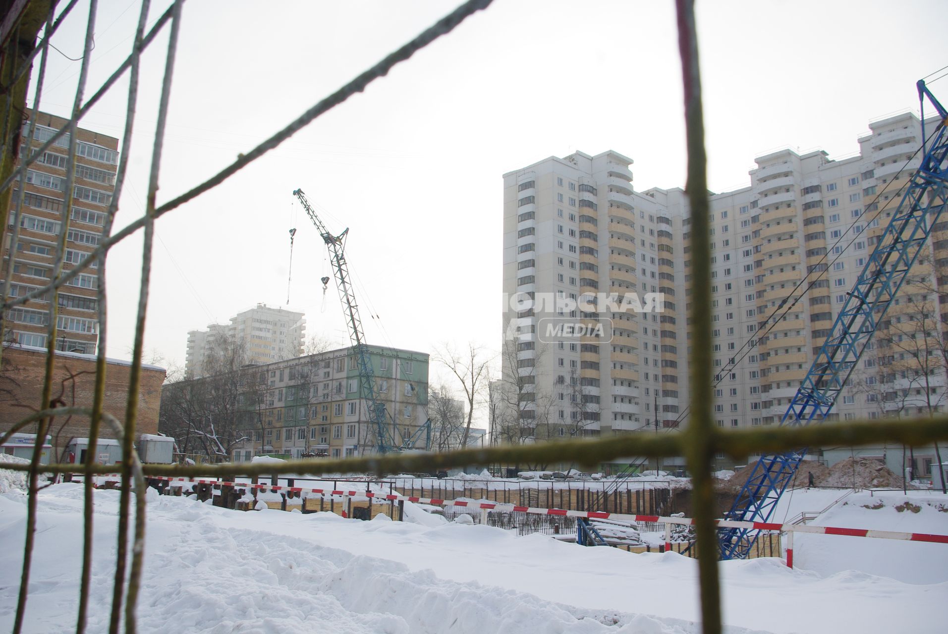 На месте снесенного дома возводят новый, на заднем плане хрущевка и новые дома, Москва, 17 февраля 2011 года, метро Кузьминки. Снос домов, новое жилье, хрущевка, строительство, ипотека, затройка города