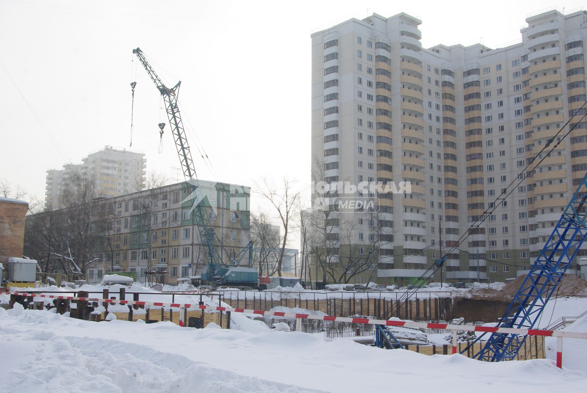 На месте снесенного дома возводят новый, на заднем плане хрущевка и новые дома, Москва, 17 февраля 2011 года, метро Кузьминки. Снос домов, новое жилье, хрущевка, строительство, ипотека, затройка города