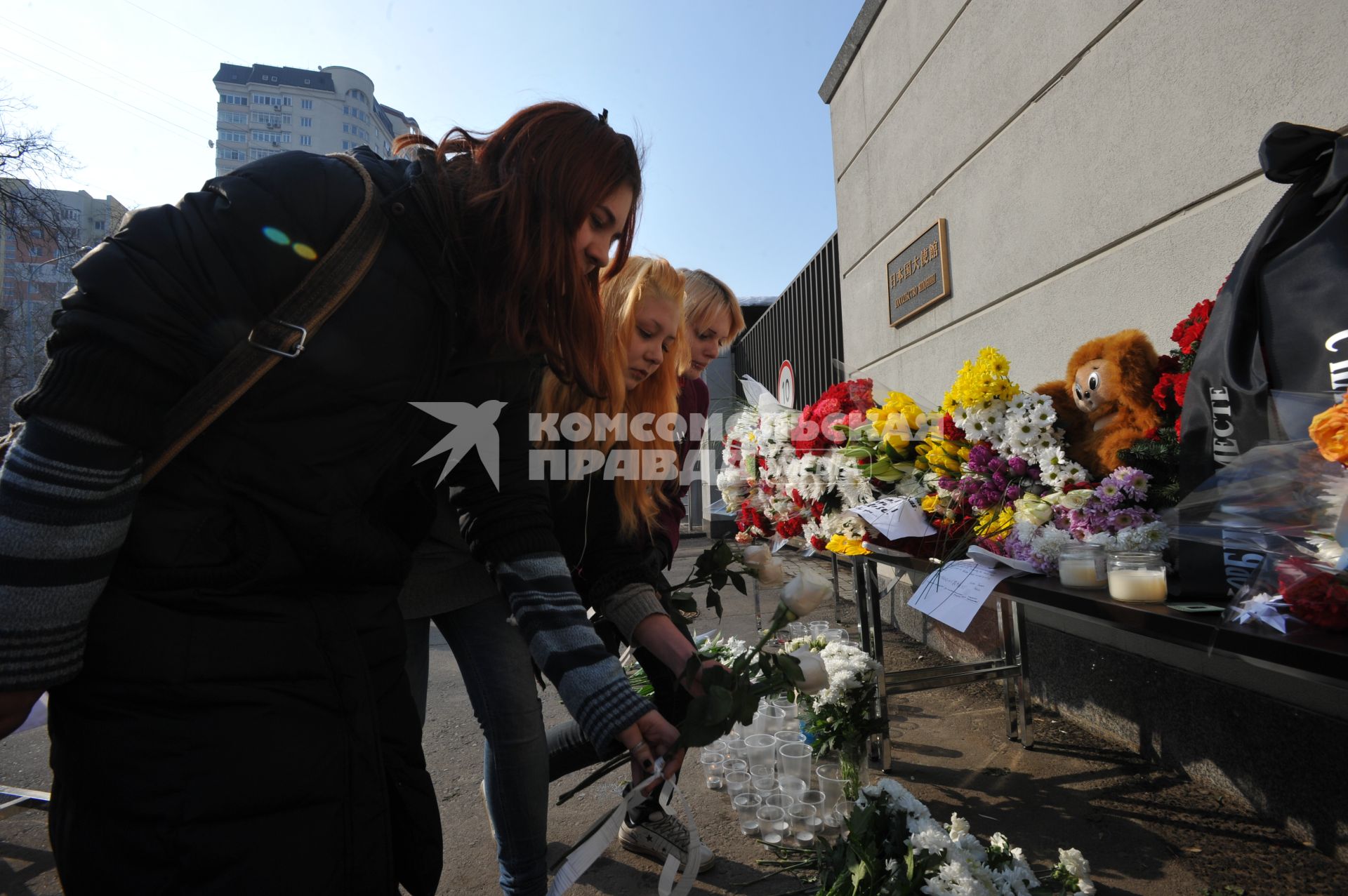 14 марта 2011Люди несут цветы и свечи к посольству Японии в Москве