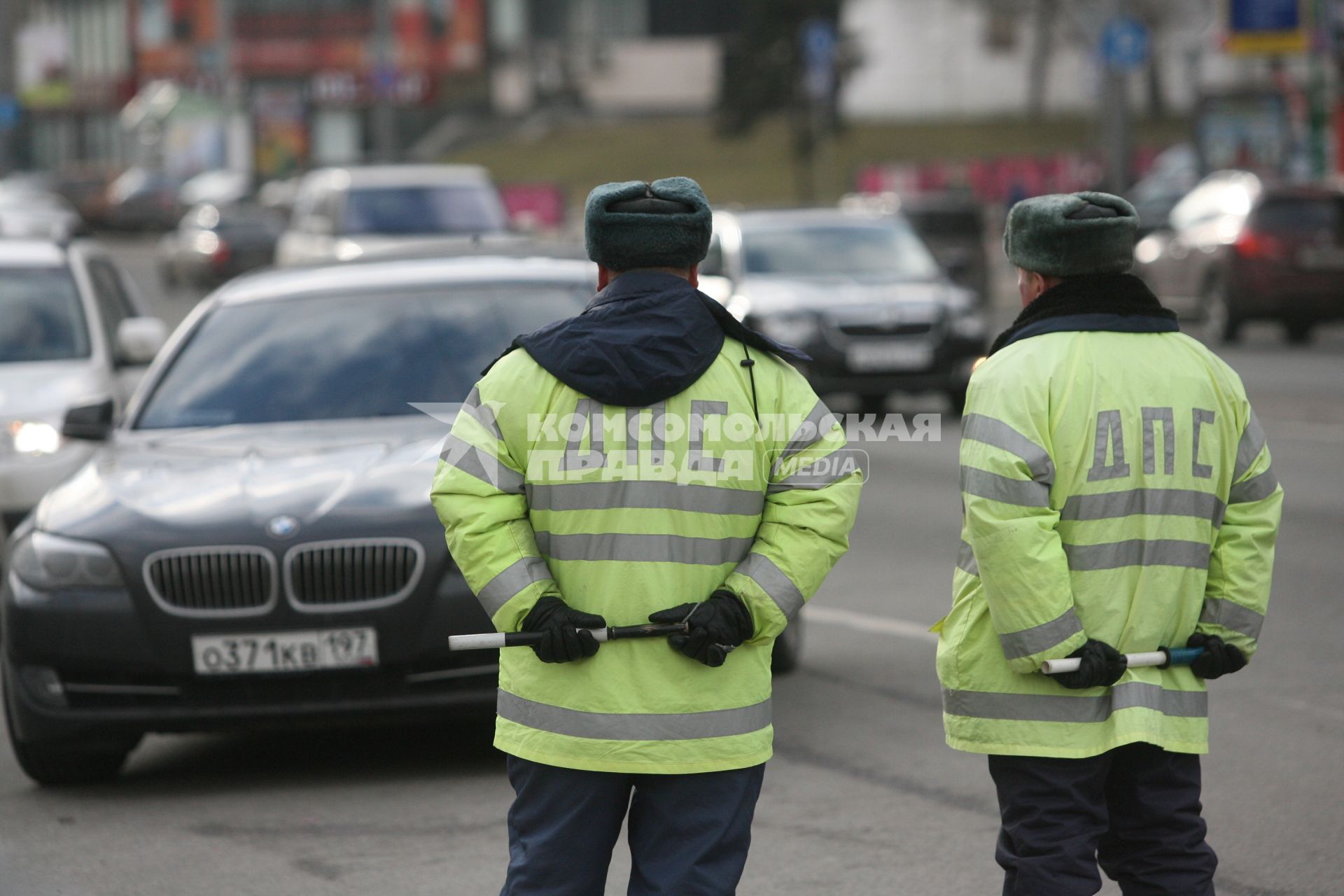 Два пузатых гаишника стоят на дороге с полосатыми палочками за спиной, Москва, 10 апреля 2011 года