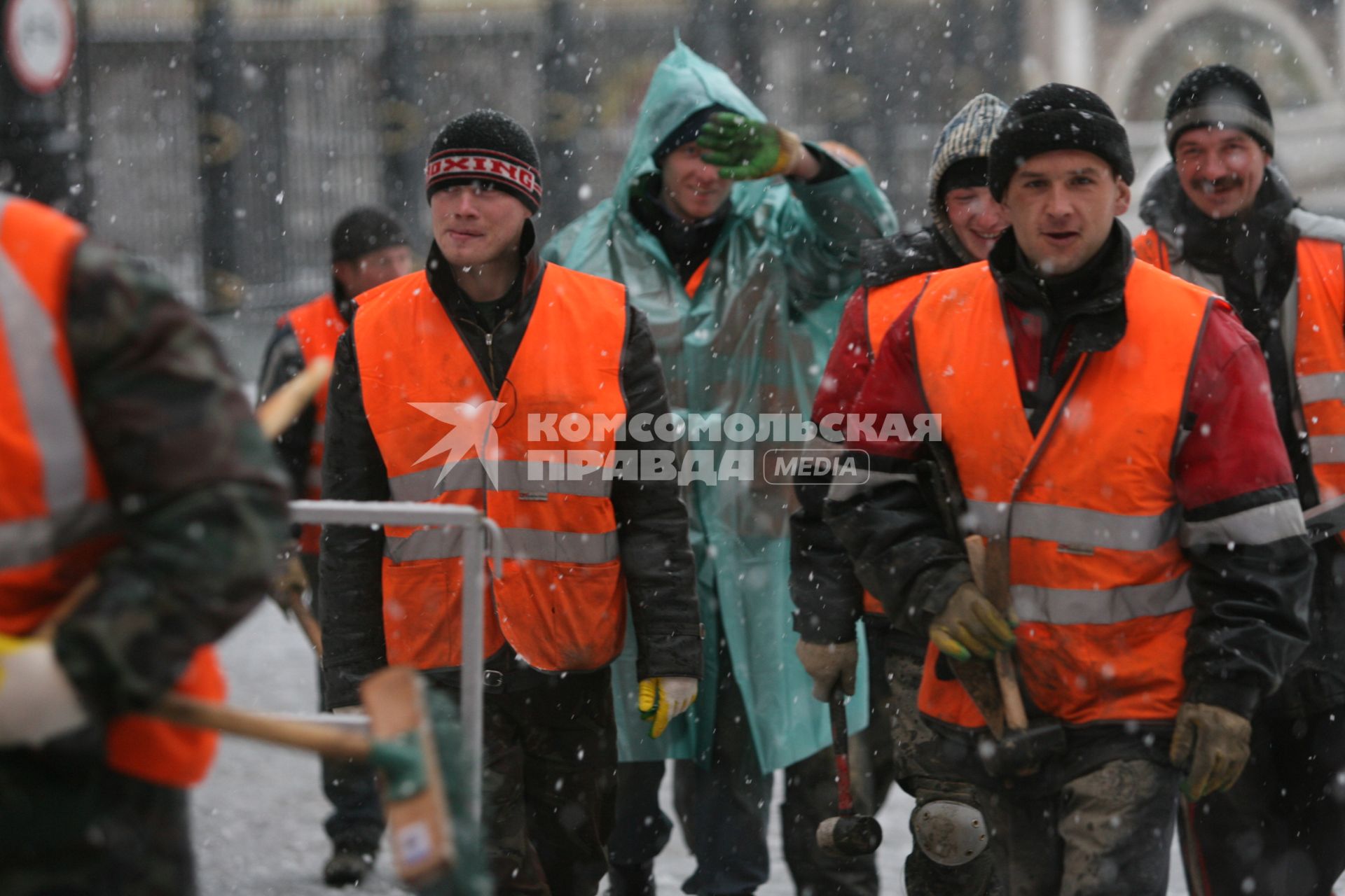 В начале апреля неожиданно выпал снег, гастарбайтеры идут на уборку города, Москва, 9 апреля 2011 года