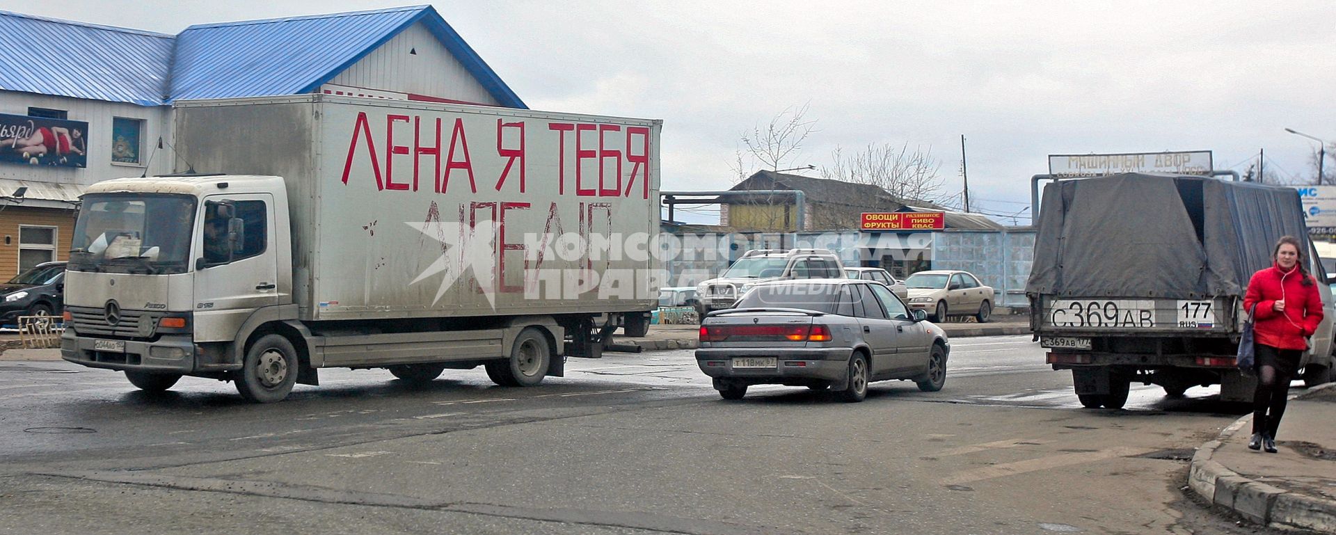 На машине, проезжающей мимо девушки, надпись \"Лена, я тебя люблю\", Москва, 11 апреля 2011 года