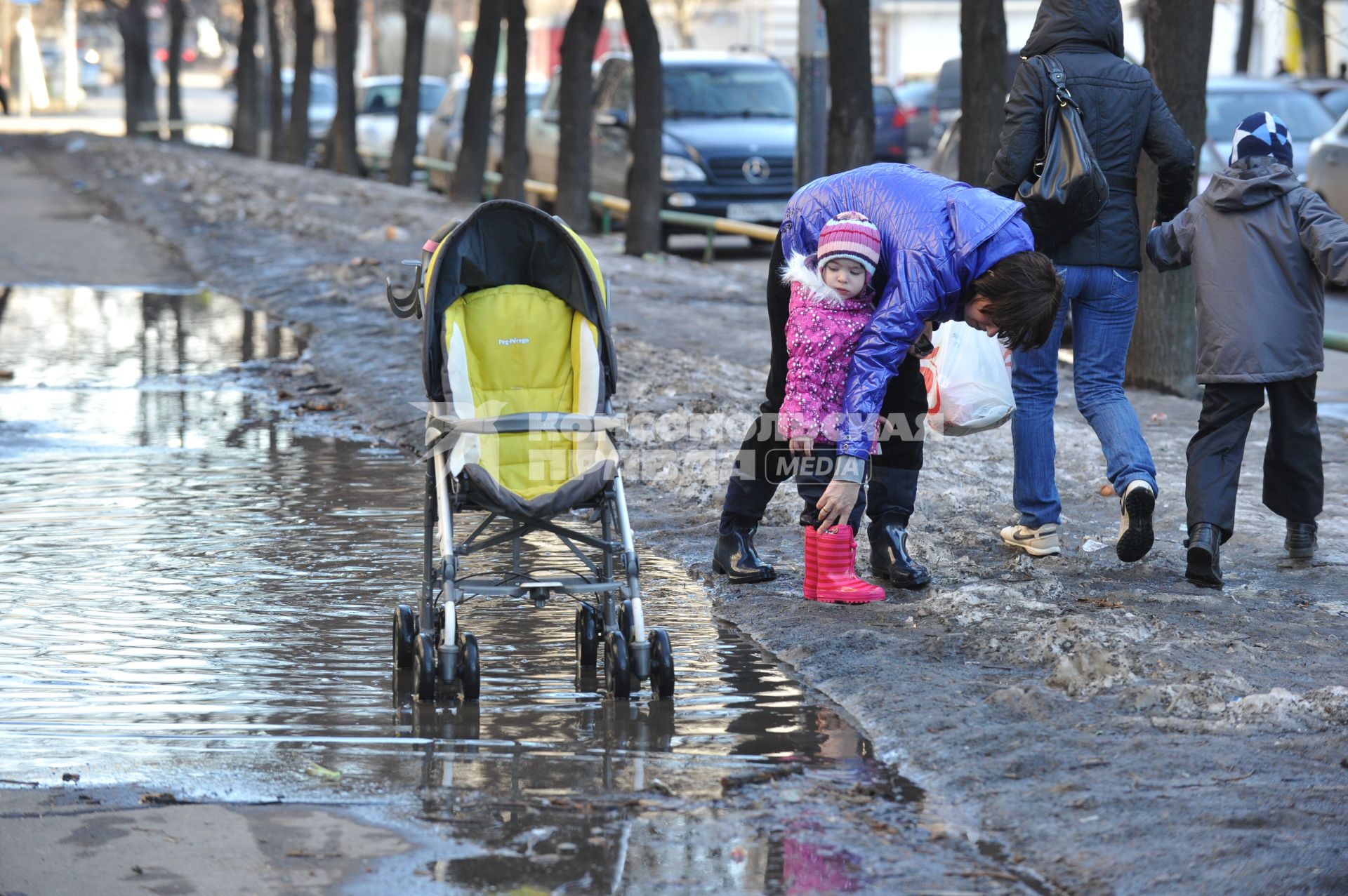 04 апреля 2011 г. Россия, Москва. Дети и их родители. лужа на тротуаре