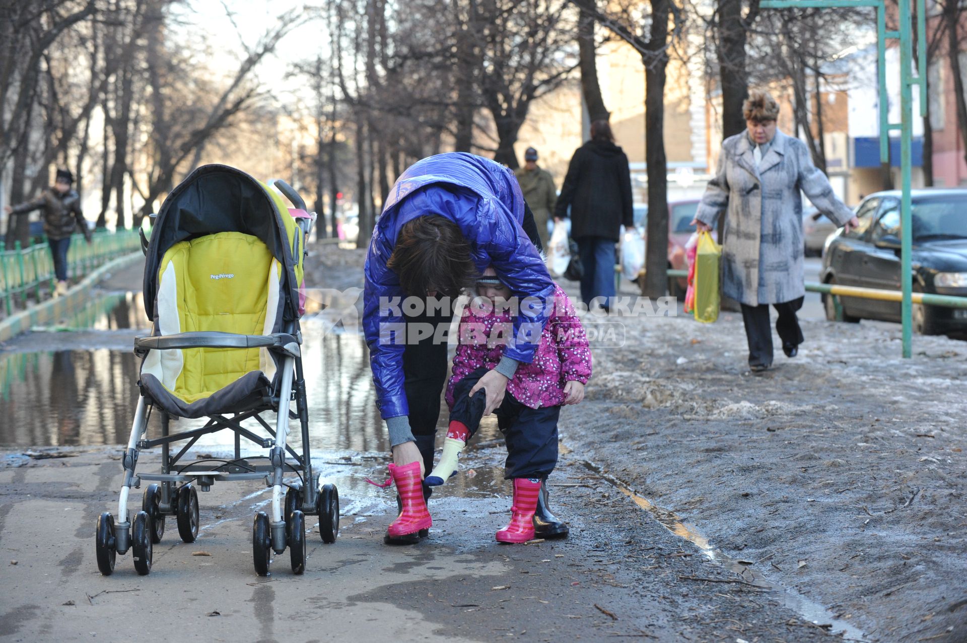 04 апреля 2011 г. Россия, Москва. Дети и их родители. Лужа на тротуаре.