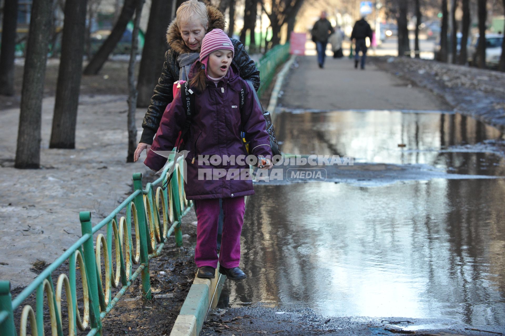 04 апреля 2011 г. Россия, Москва. Дети и их родители. Лужа на тротуаре.