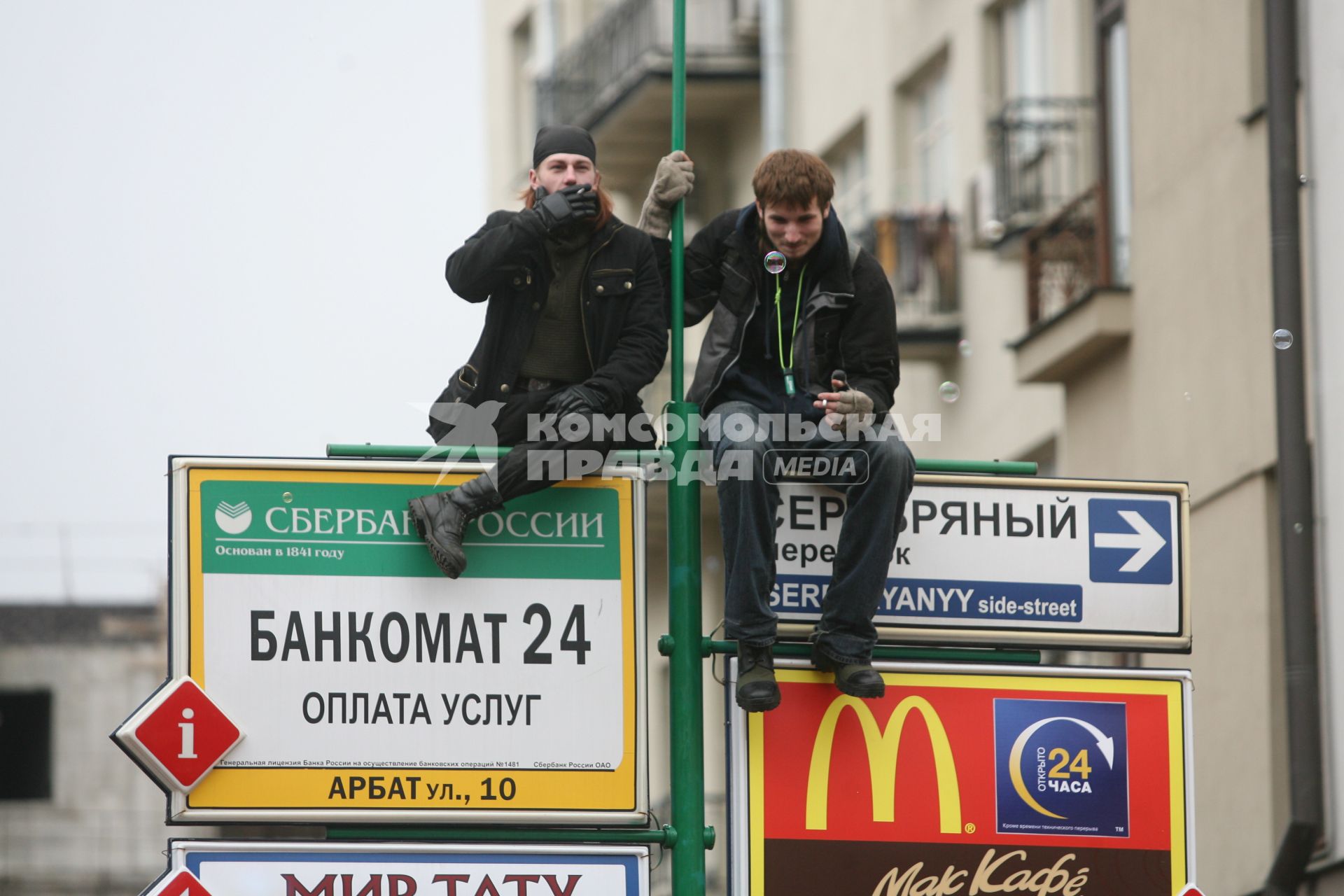 Два молодых человека залезли на столб с вывеской \"Сбербанк\", Москва, 12 апреля 2011 года