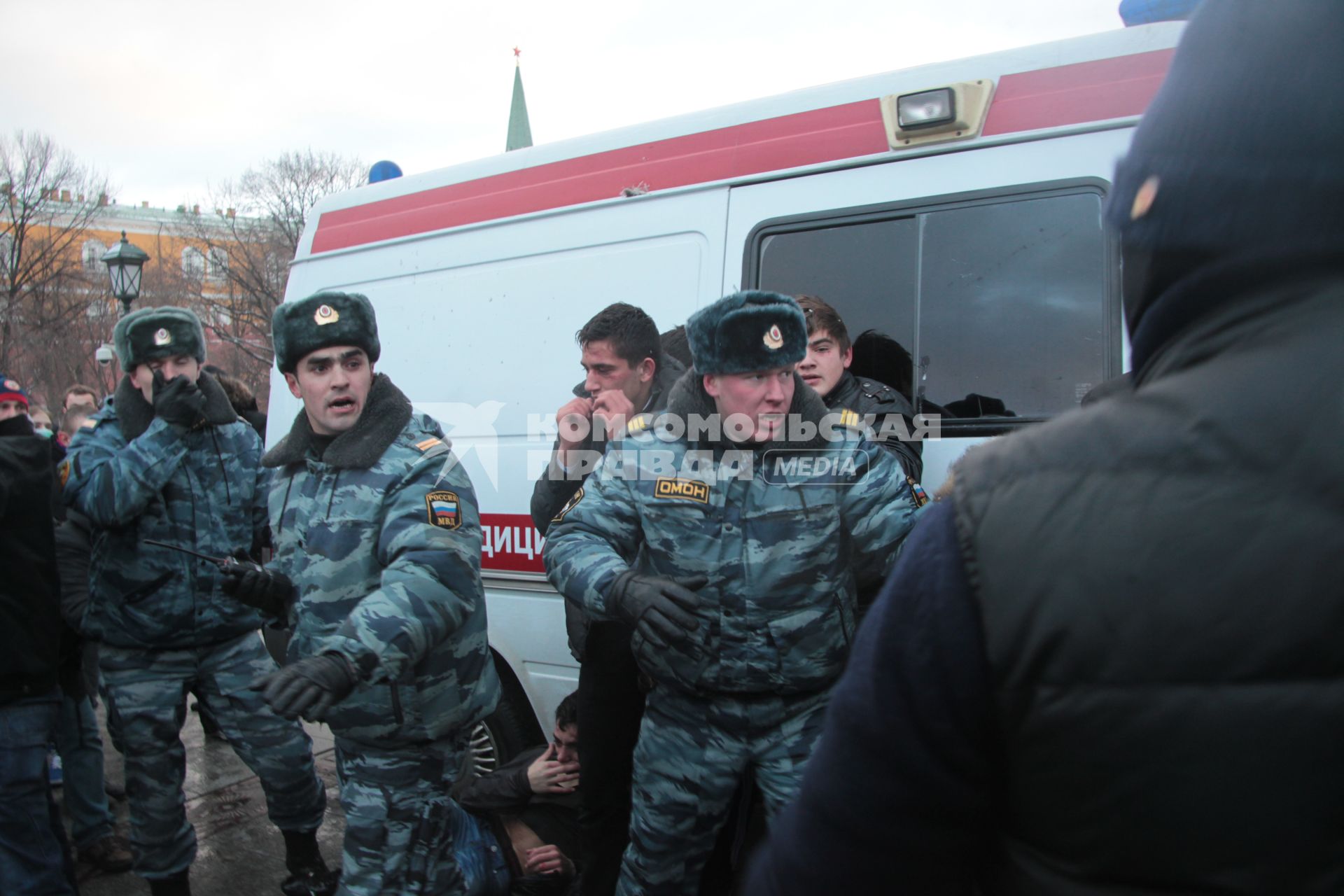 Митинг на Манежной площади, который начался в память о погибшем болельщике СПАРТАКА Егоре Свиридове и перерос в массовые беспорядки и погром. На снимке: Четверо избитых похожих на кавказцев людей стоят возле автомобиля скорой помощи, охраняются сотрудниками ОМОНа. 11 декабря 2010 года.