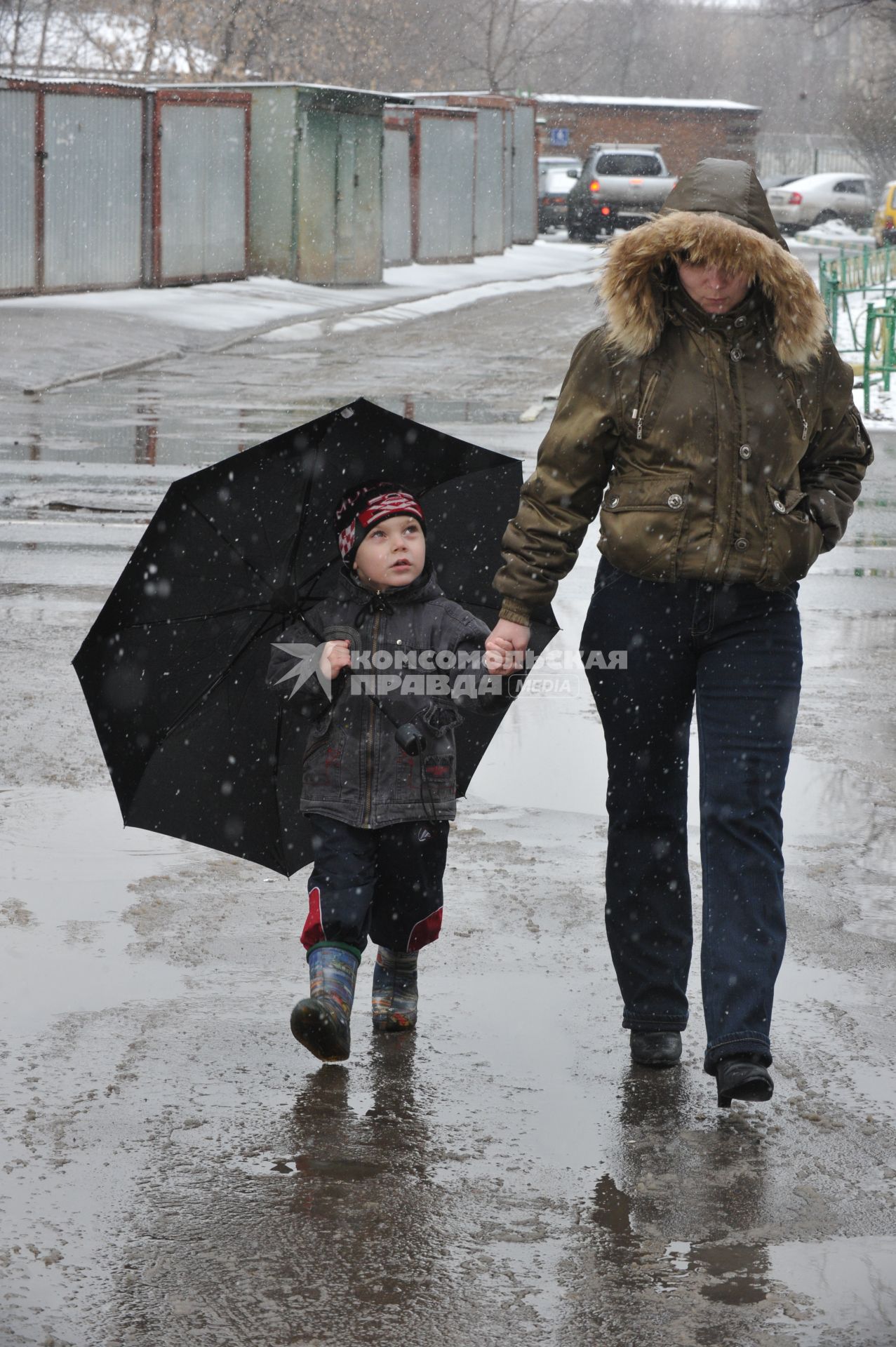 12 апреля 2011г. Москва. Снег, лужи, слякоть.  Женщина с ребенком.