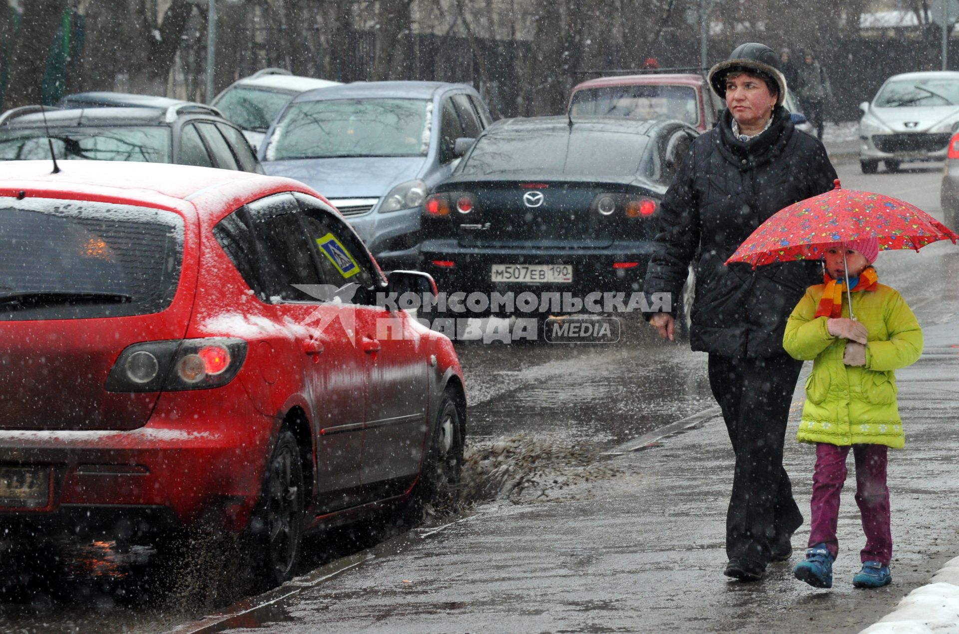 12 апреля 2011г. Москва. Снег, лужи, слякоть.  Женщина с ребенком.