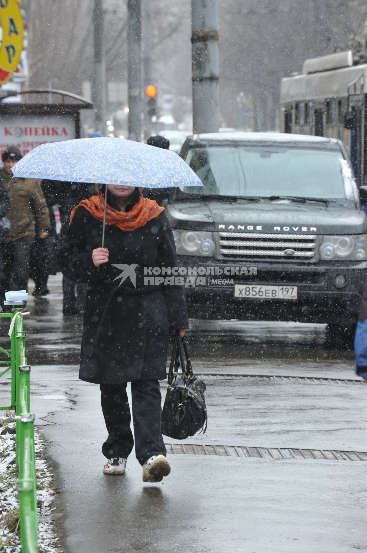 12 апреля 2011г. Москва. Снег, снегопад.  Женщина с зонтом. Манина на тротуаре.