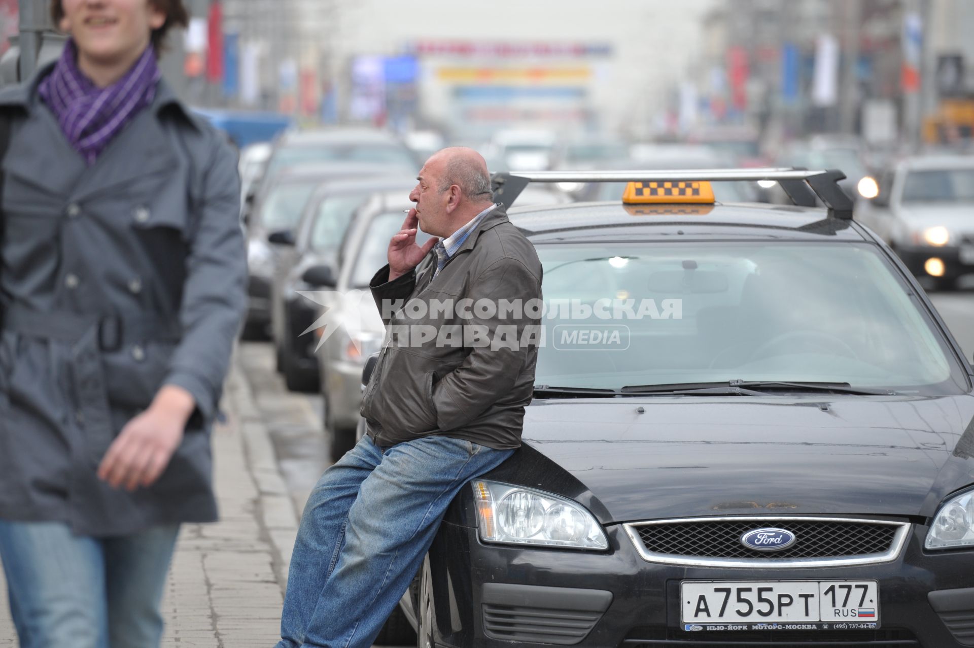 Таксист сидит на машине и курит в ожидании пассажиров, Москва, 5 мая 2011 года