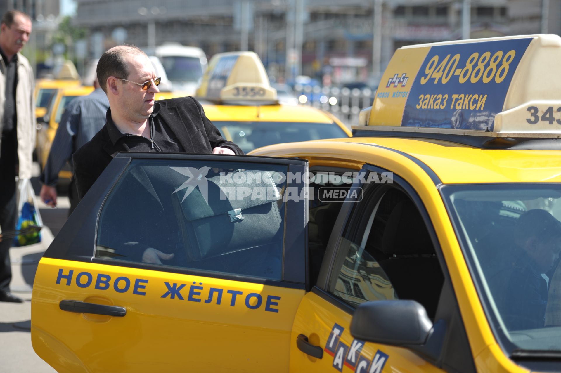 Мужчина в костюме садится в желтое такси у Ленинградского вокзала, Москва, 11 мая 2011 года