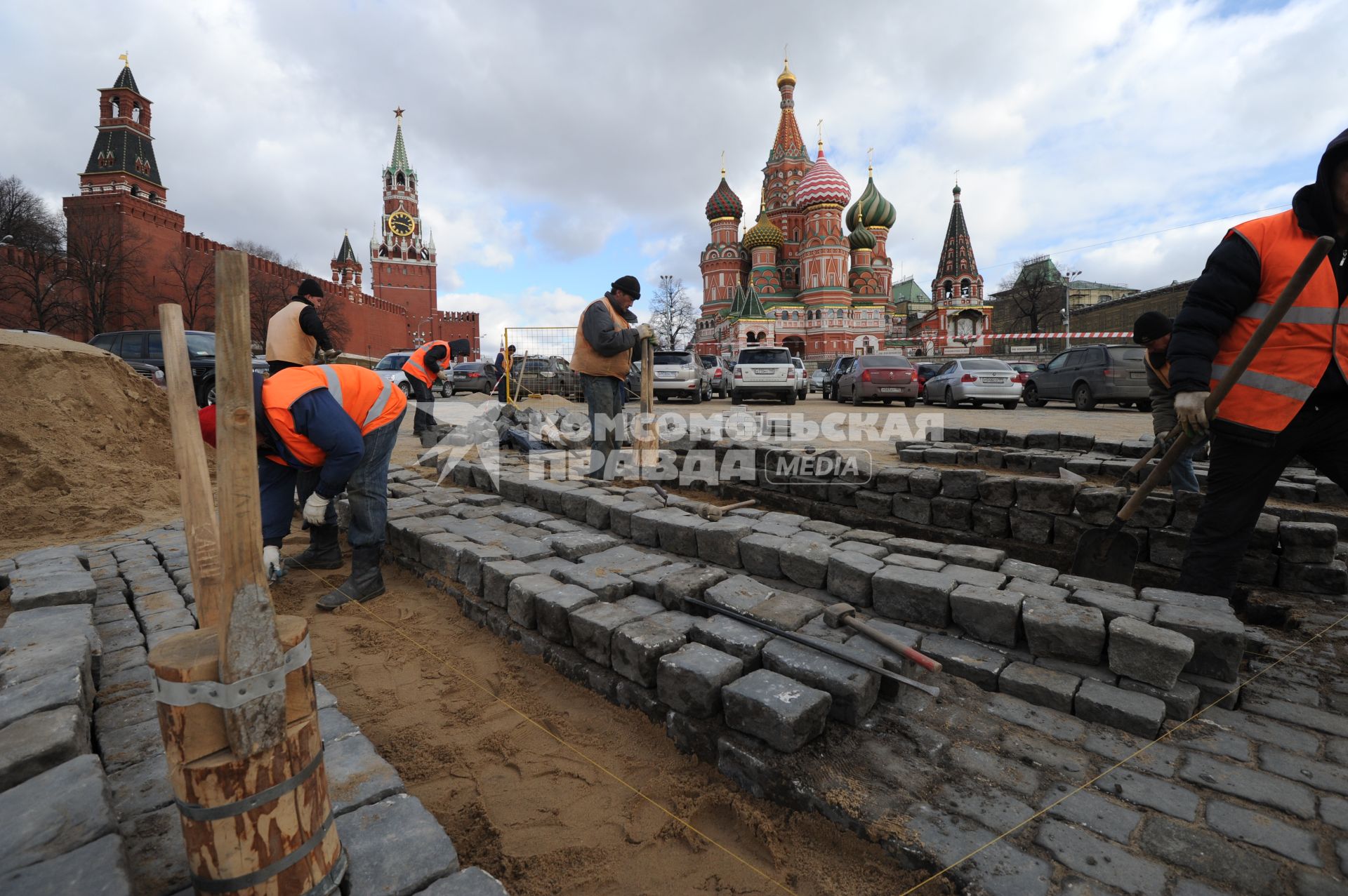 20 апреля 2011 год.Россия, Москва. Работы по ремонту и перекладка брусчатки на Красной площади. На заднем плане Храм Василия Блаженного и Спасская башня (слева).