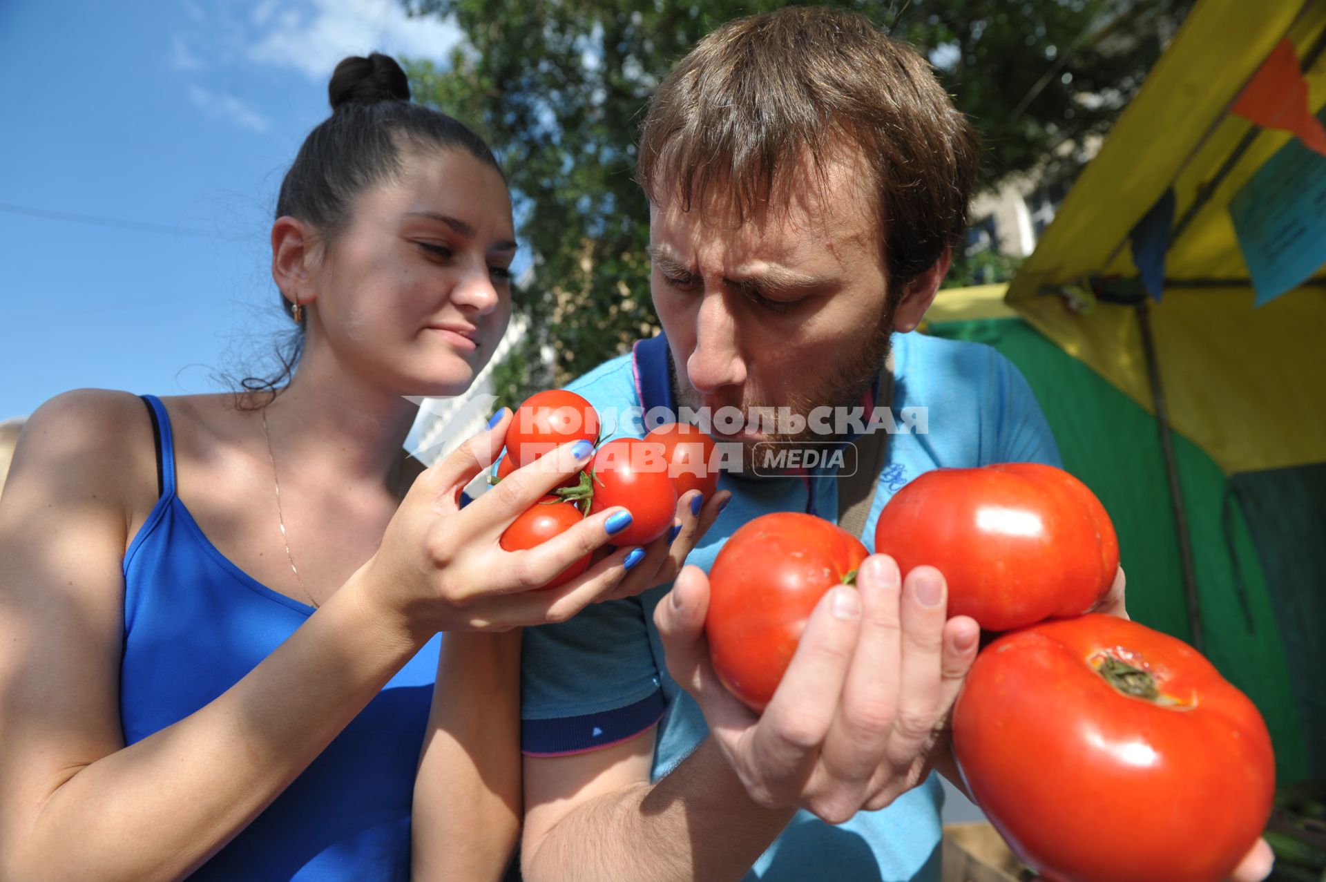 Молодой человек и девушка с помидорами в руках,  Москва,10 июня 2011 года