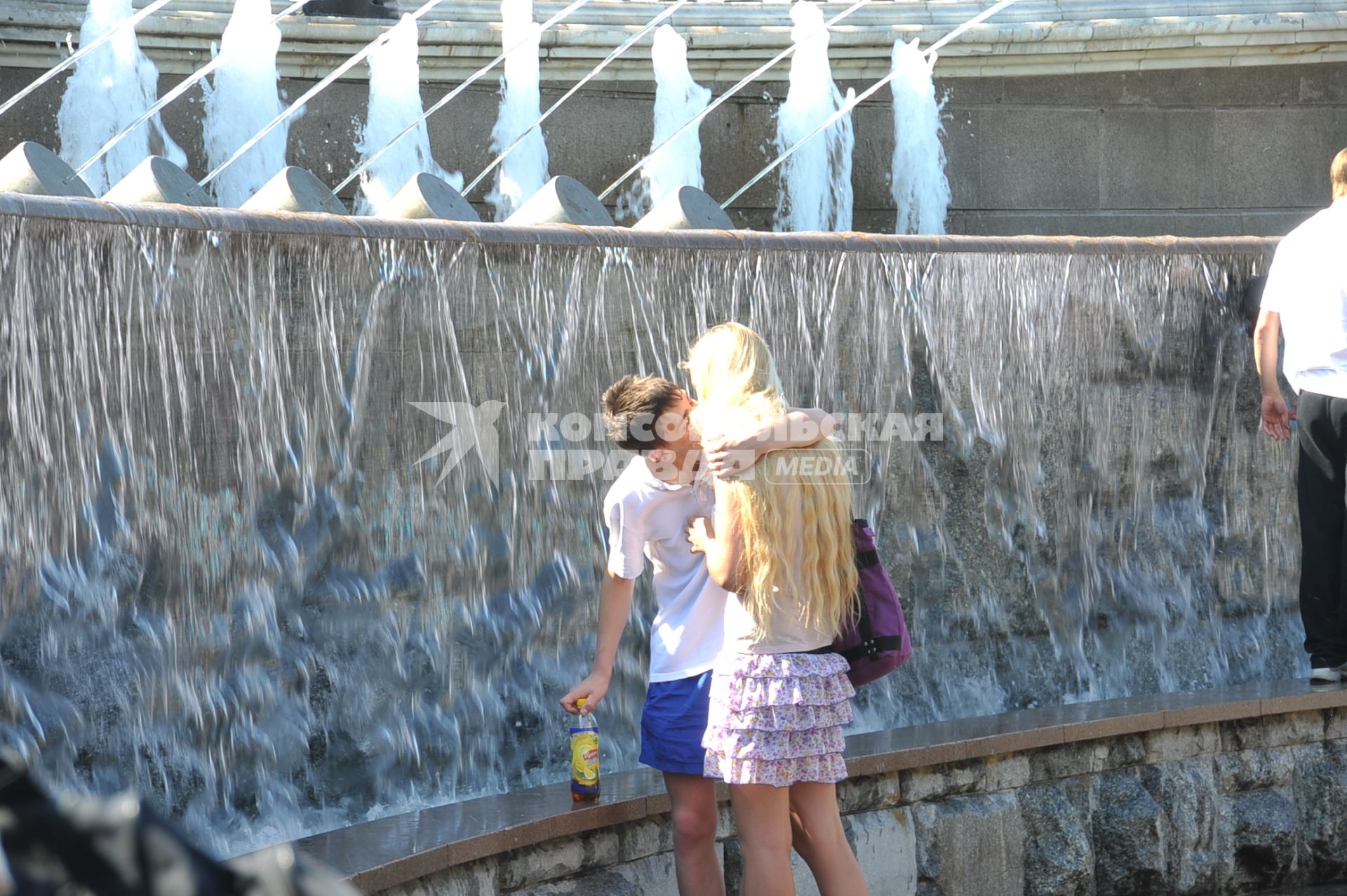 Молодой человек у фонтана обнимает и целует девушку. 2 июня 2011 года.