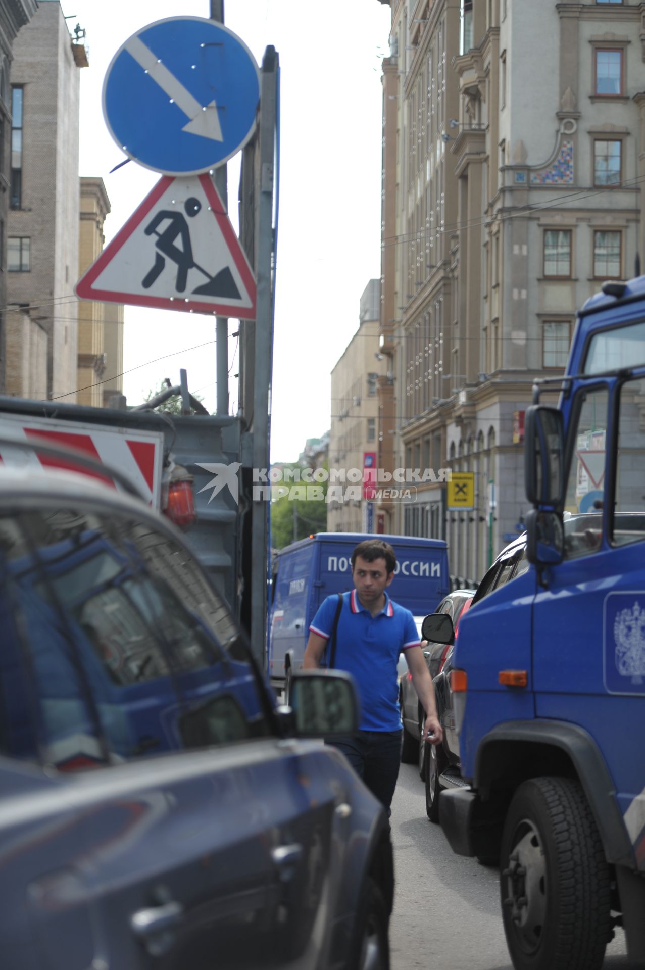 Пешеход идет мимо  машин в месте ремонта дороги, Москва, 28 июня 2011 года