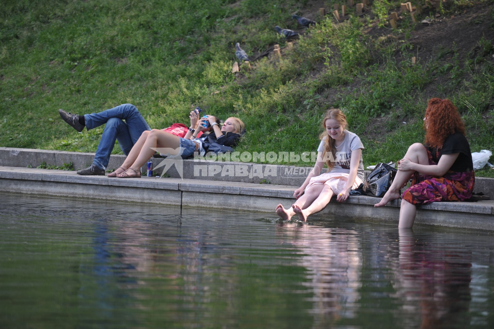 Горожане загорают вдоль у пруда на Патриарших, Москва, 28 июня 2011 года