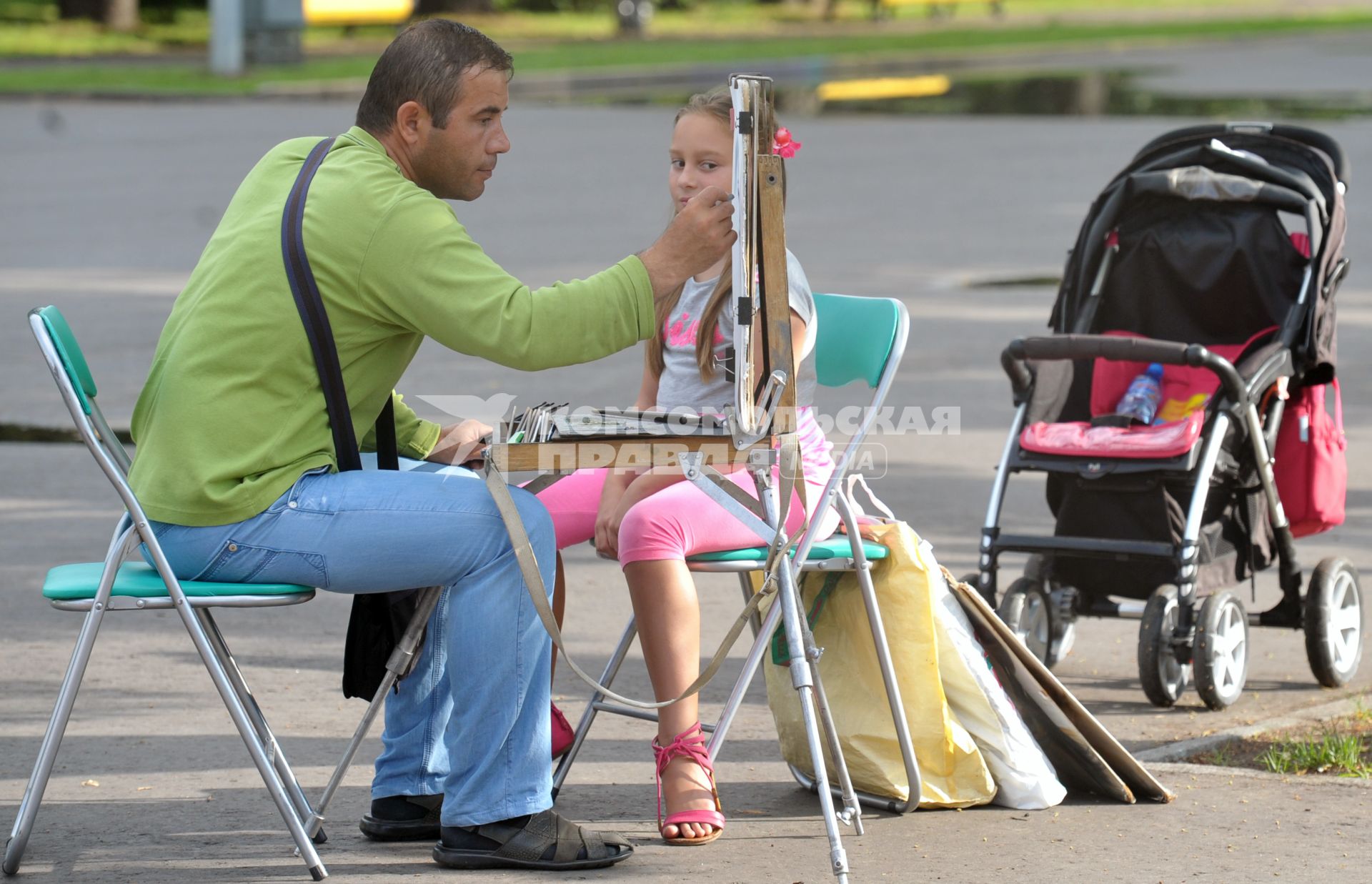 Художник  в ЦПКиО им. Горького рисует портрет девочки, Москва, 13 июля 2011 года.