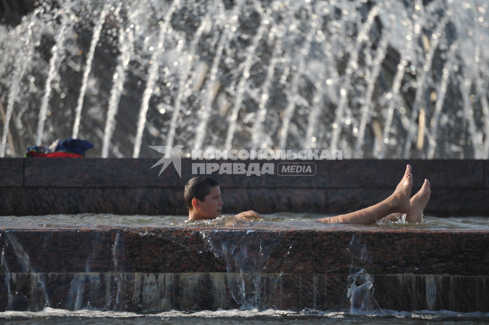 Горожане купаются в фонтане в жару, Москва, 16 июля 2011 года.