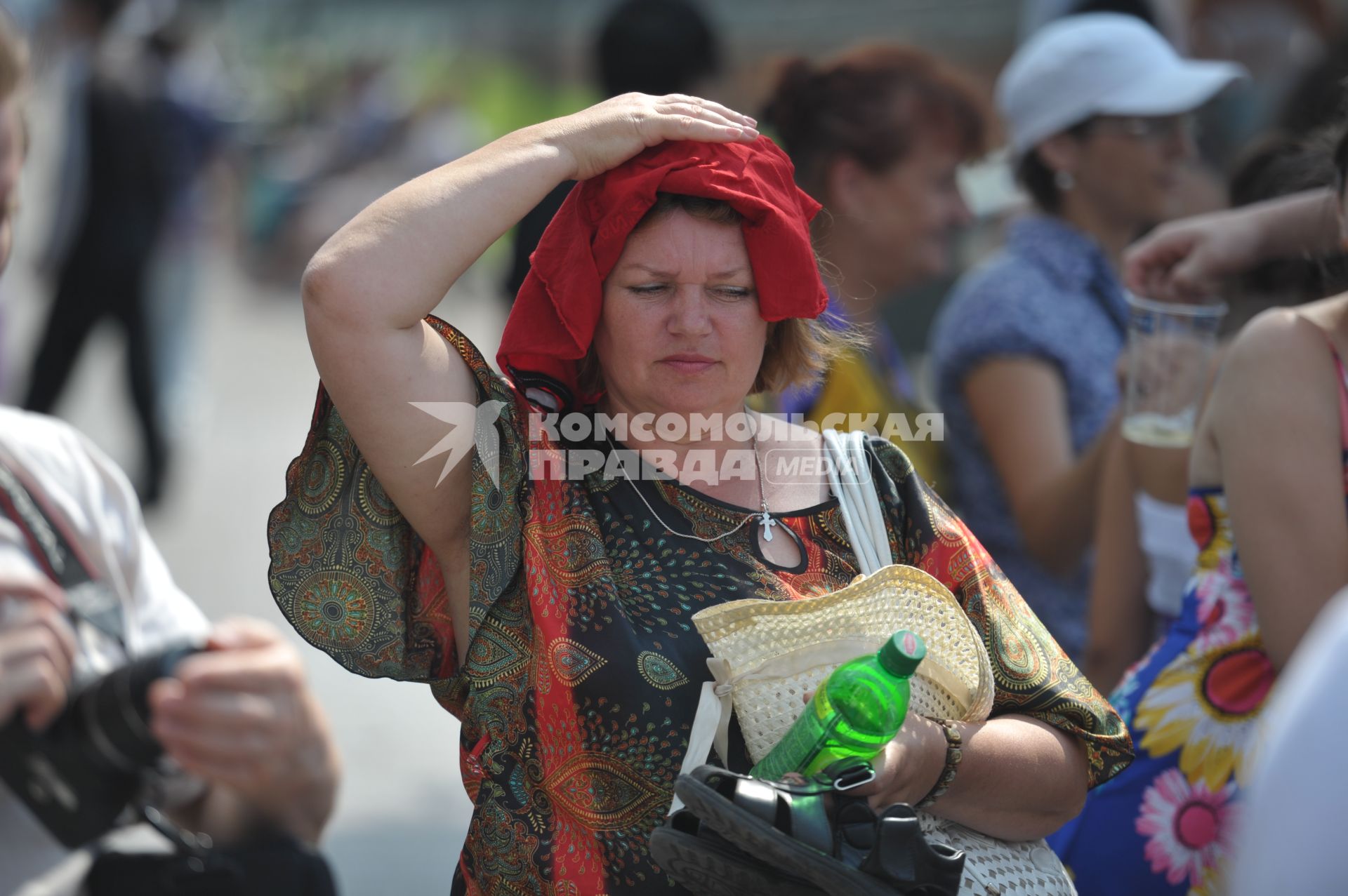 Женщина накрыла голову майкой, спасаясь от жары, Москва, 16 июля 2011 года.