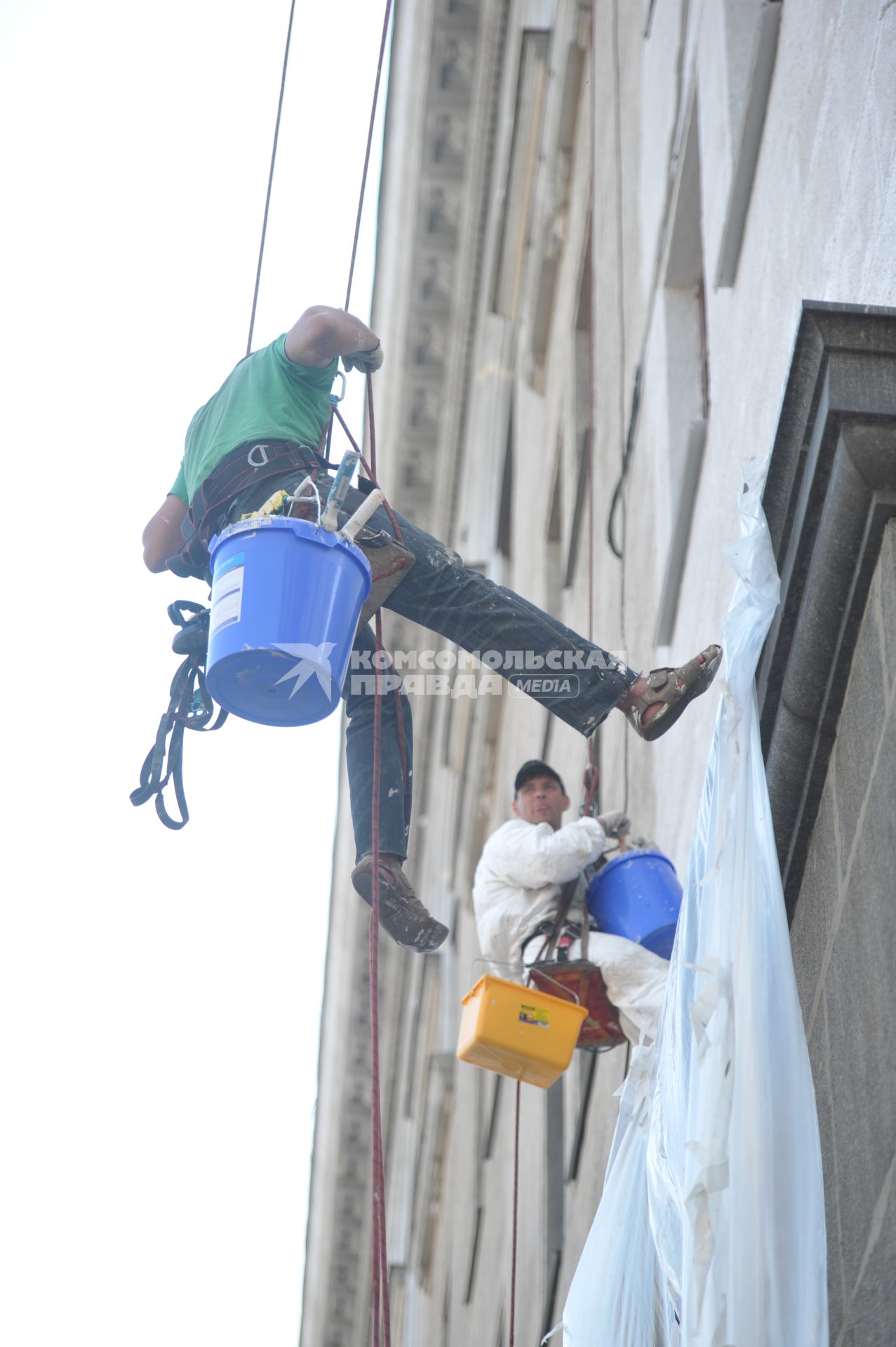 Гастарбайтеры красят фасад дома, Москва, 28 июля 2011 года.