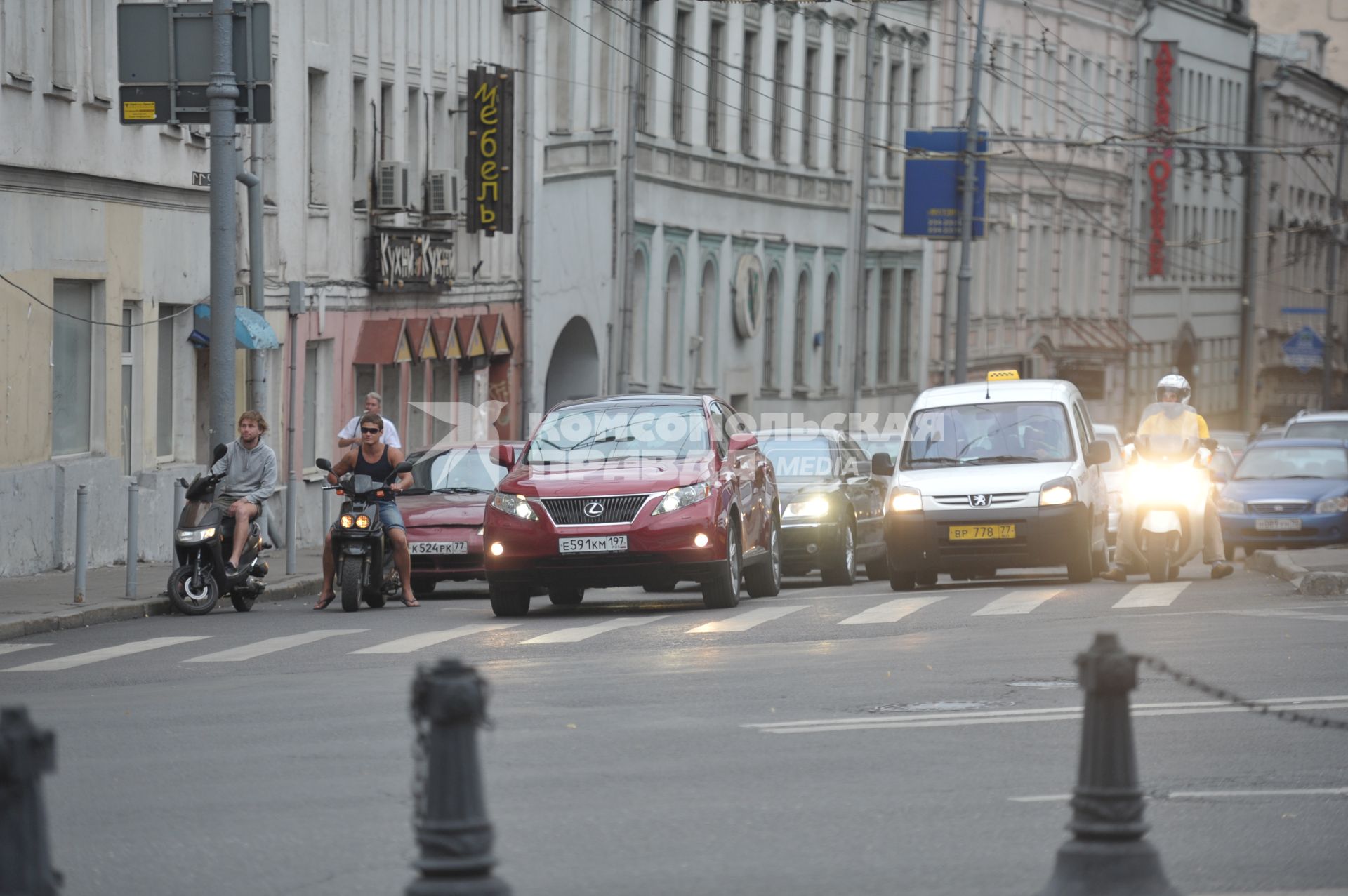 Скутеры и мопеды на дороге города среди машин, Москва, 26 июля 2011 года.