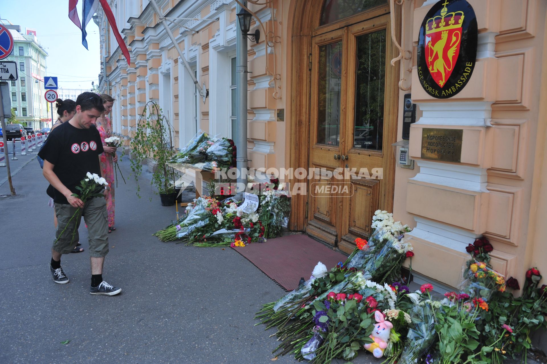 Люди приносят цветы к посольству Норвегии  в память о погибших в двойном теракте в Осло. Москва.  24 июля 2011 года.