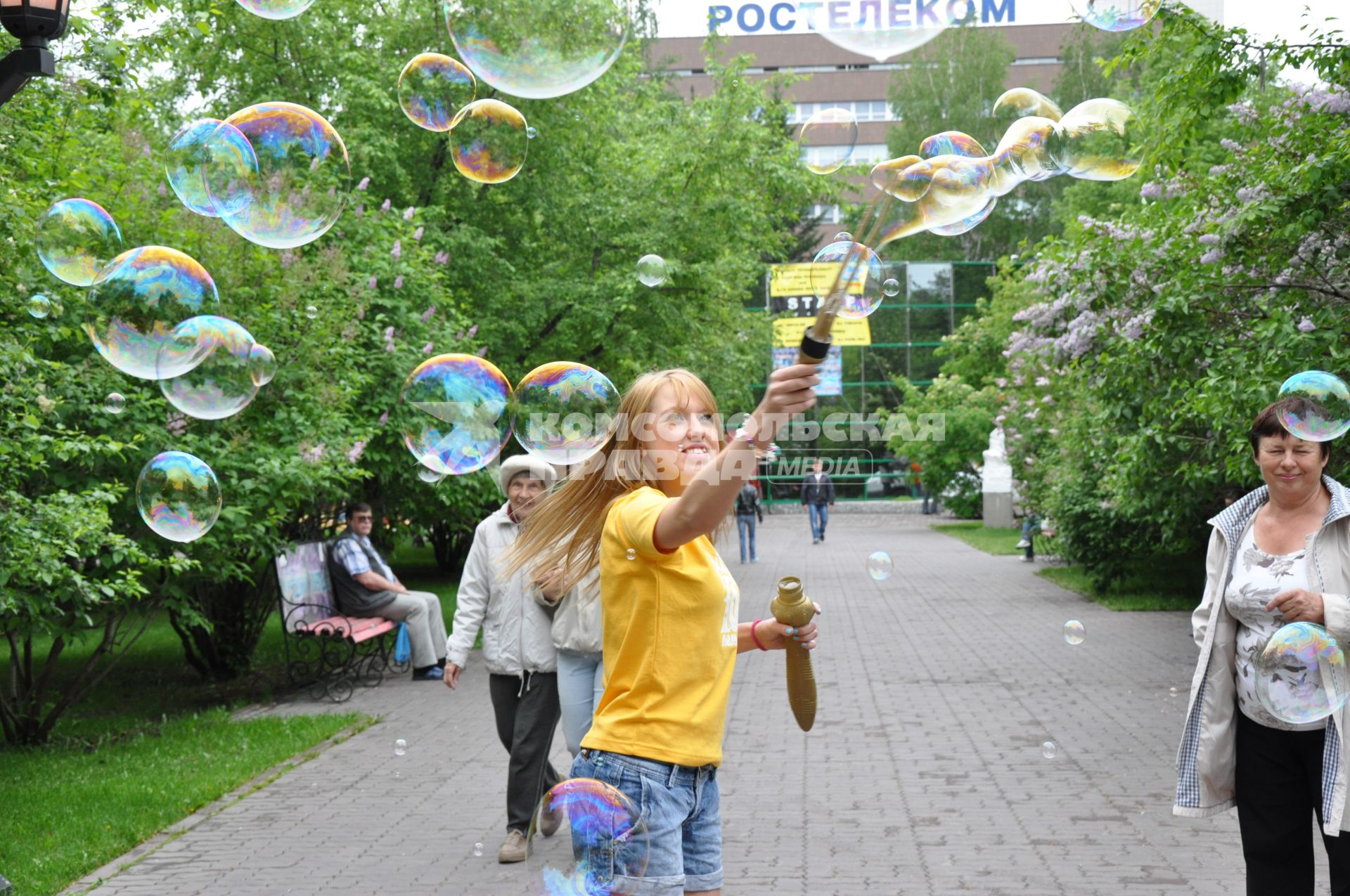 Девочка на улице пускает большие мыльные пузыри. 1 июня 2011 года.