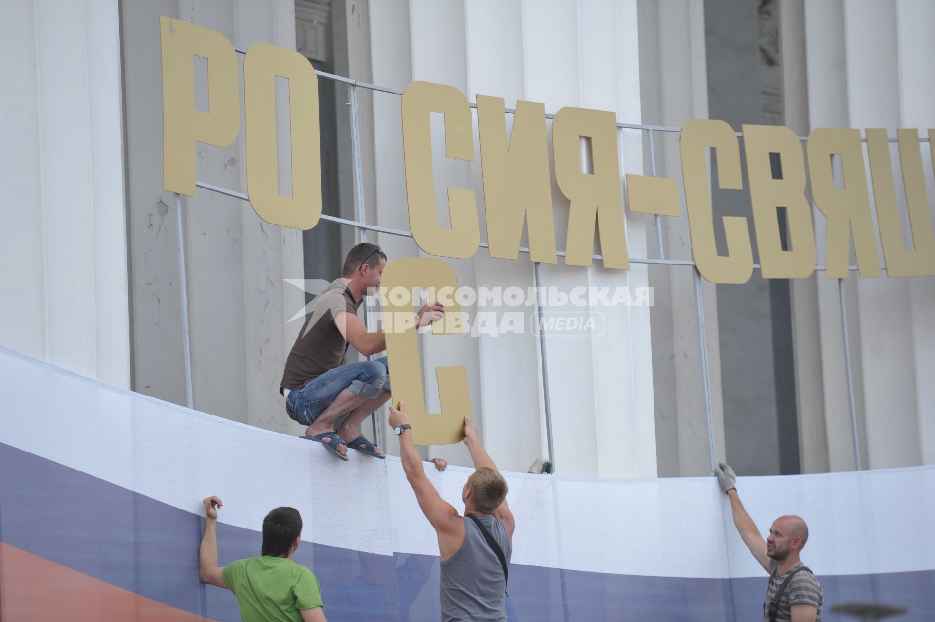 Молодые люди устанавливают надпись. 10 июня 2011.