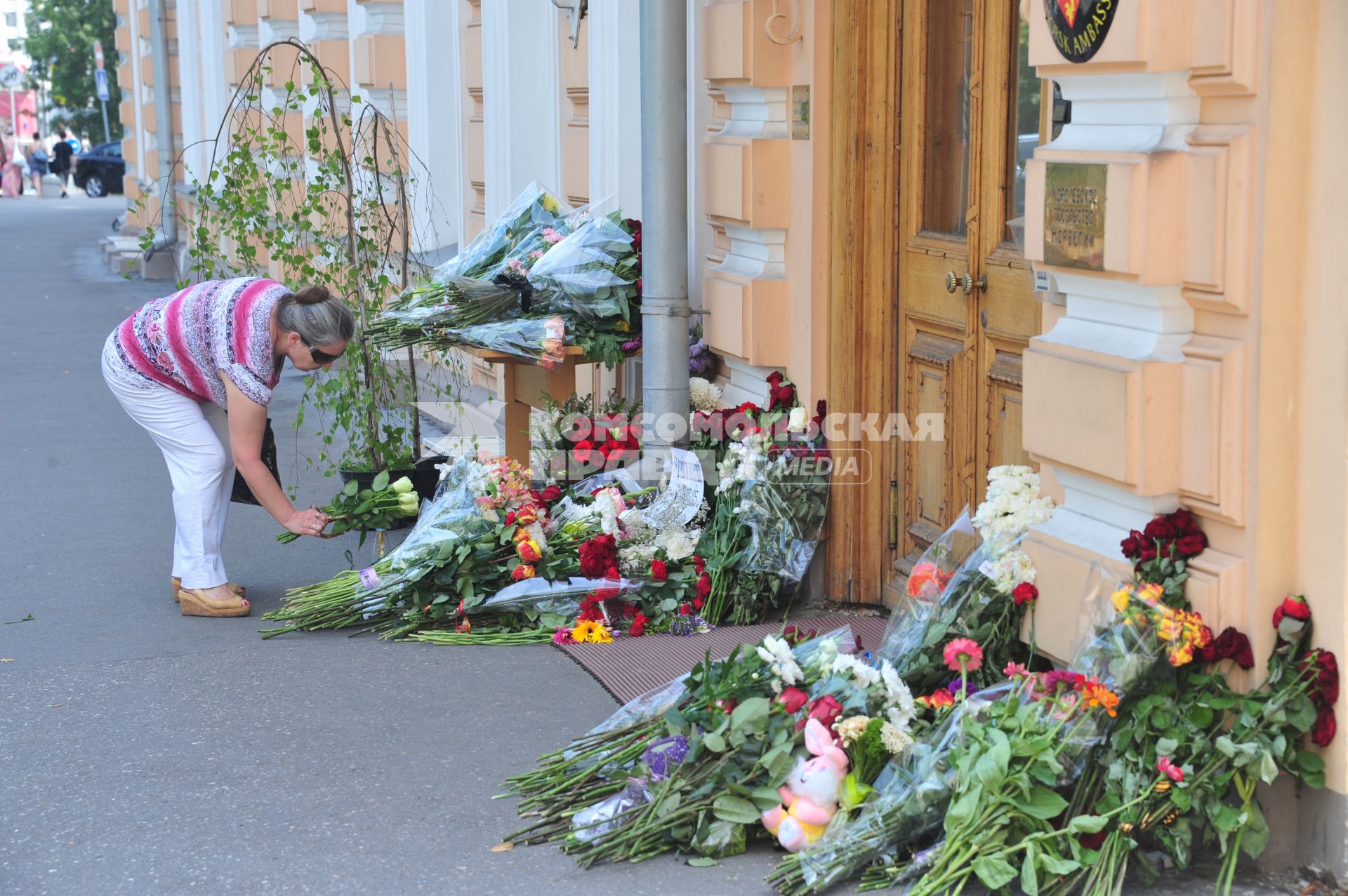 Люди приносят цветы к посольству Норвегии  в память о погибших в двойном теракте в Осло. Москва.  24 июля 2011 года.