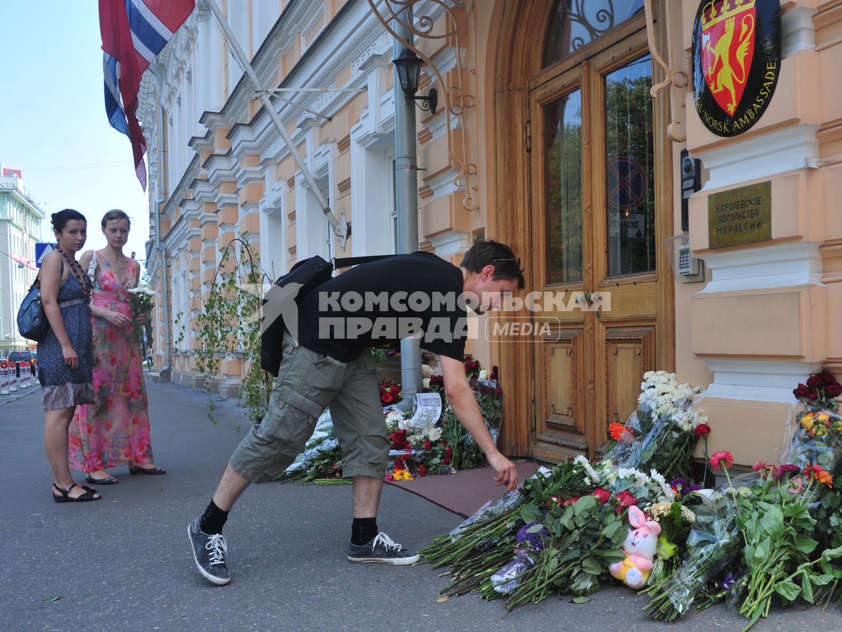 Люди приносят цветы к посольству Норвегии  в память о погибших в двойном теракте в Осло. Москва.  24 июля 2011 года.