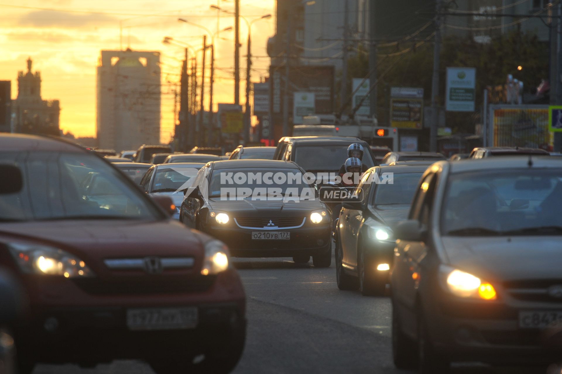 Машины стоят в автомобильной пробке. На снимке: мотоциклист движется в автомобильном потоке. 30 сентября 2011 года.