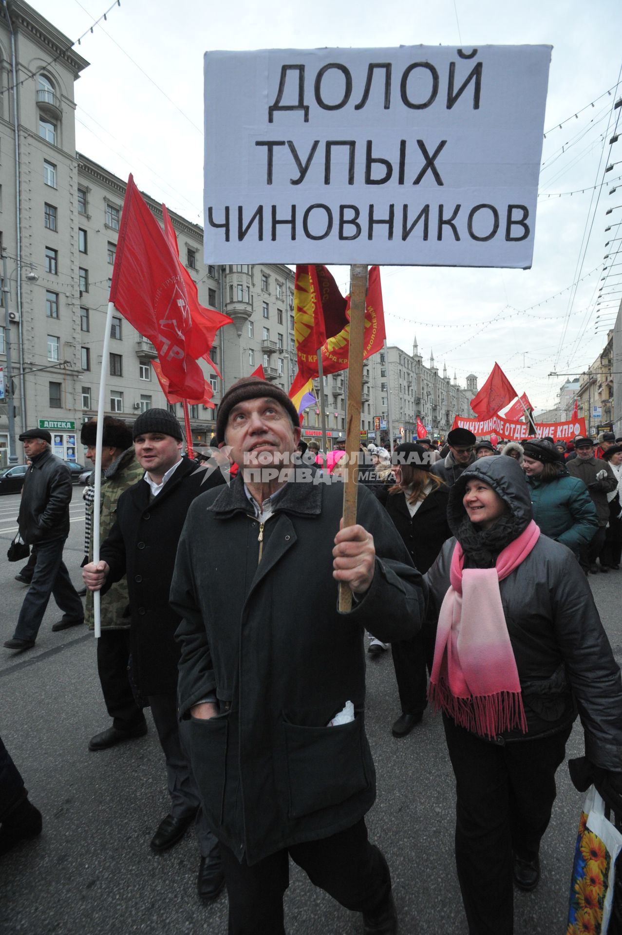 Во время шествия, приуроченного к 94-ой годовщине Октябрьской революции, на Тверской улице. На снимке: участник шествия держит лозунг ДОЛОЙ ТУПЫХ ЧИНОВНИКОВ. 07 ноября  2011 года.