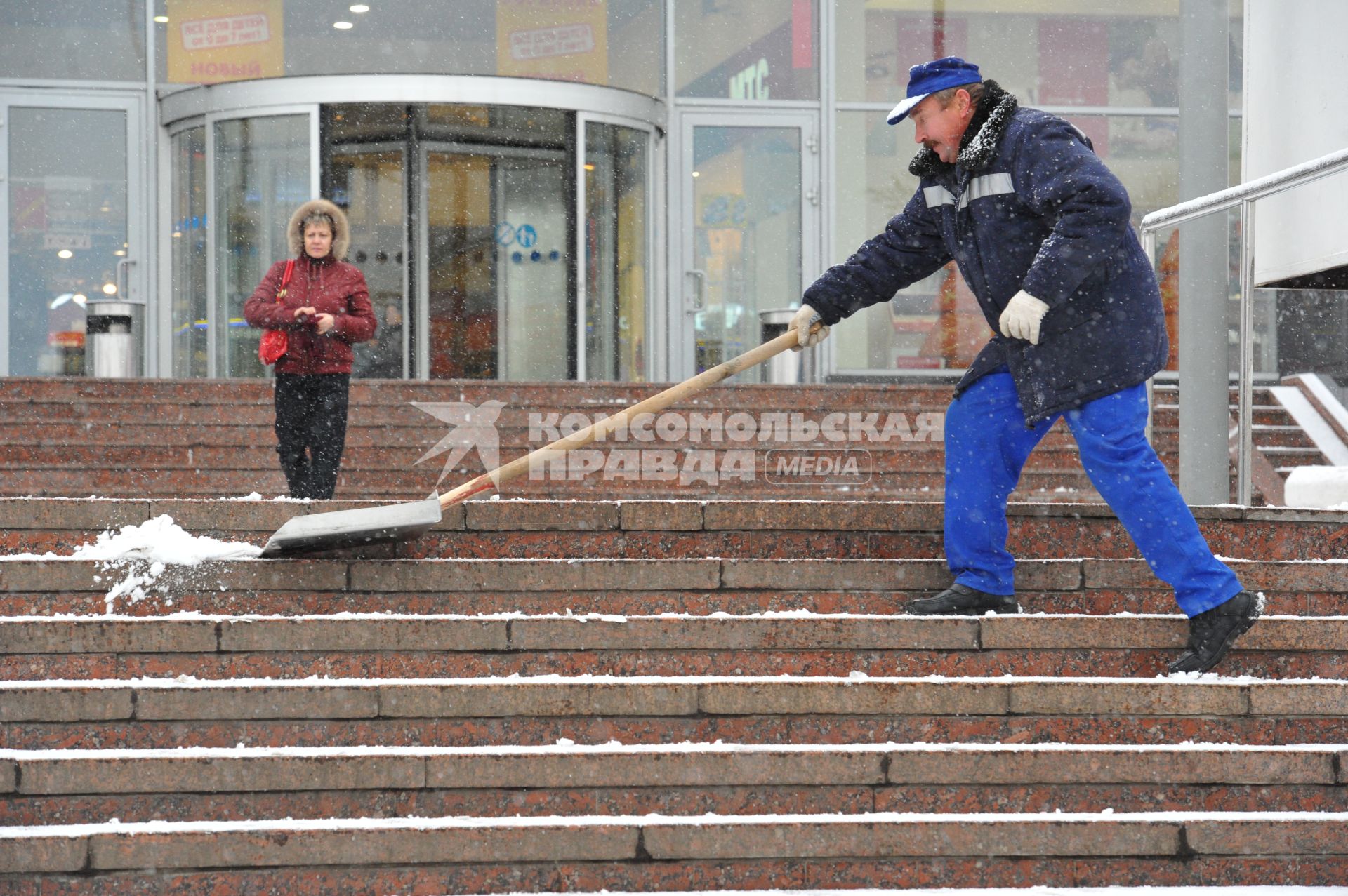 Москва. Снегопад. Мужчина чистит снег. 11 ноября 2011 года.