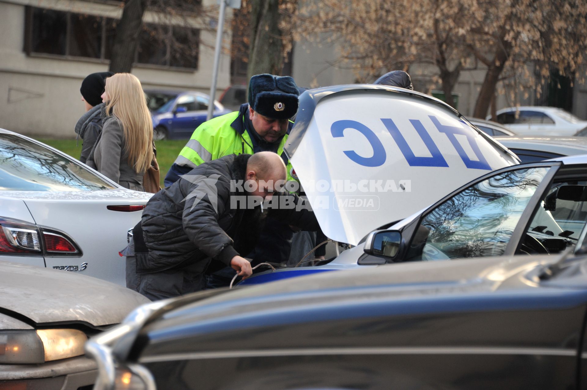 Сотрудник полиции осматривает автомобиль ДПС. 15 ноября 2011 года.