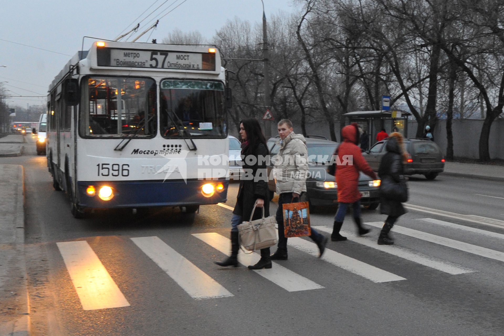 Люди переходят дорогу по пешеходному переходу. Троллейбус уступает дорогу пешеходам. 01 декабря 2011 года.