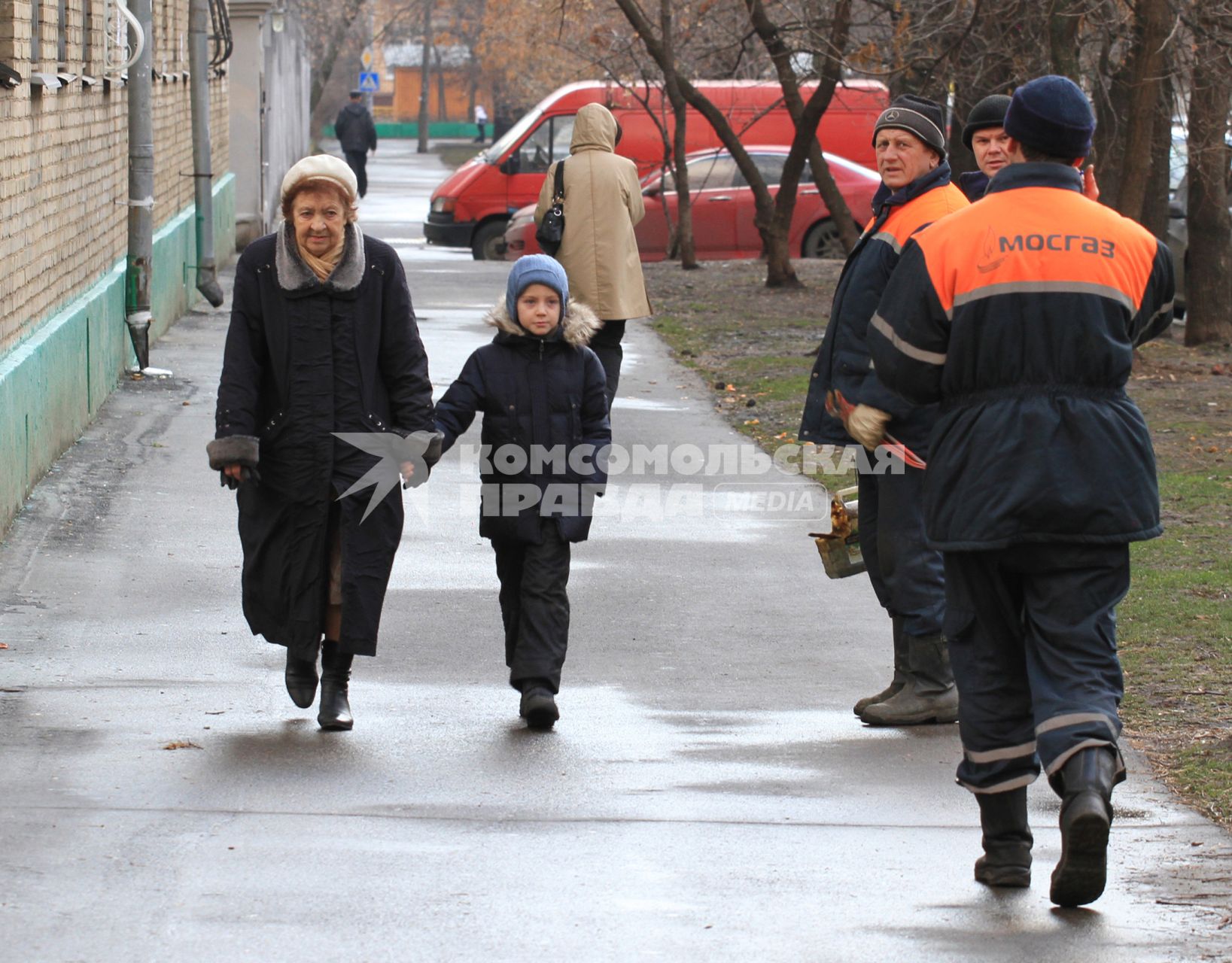 Бабушка с внуком идет по улице, мимо проходят рабочие из МОСГАЗа. 5 декабря 2011 года.