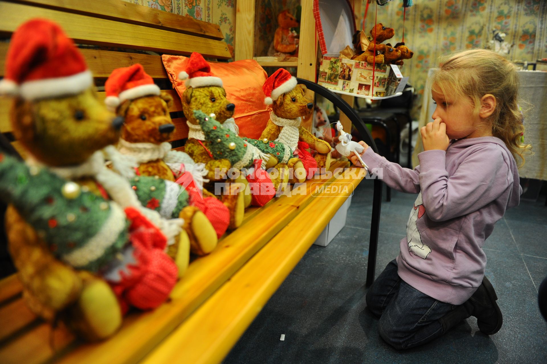 III Московская международная выставка коллекционных медведей TEDDY. На снимке: девочка рассматривает игрушечных мишек. Москва. 04 декабря 2011 года.