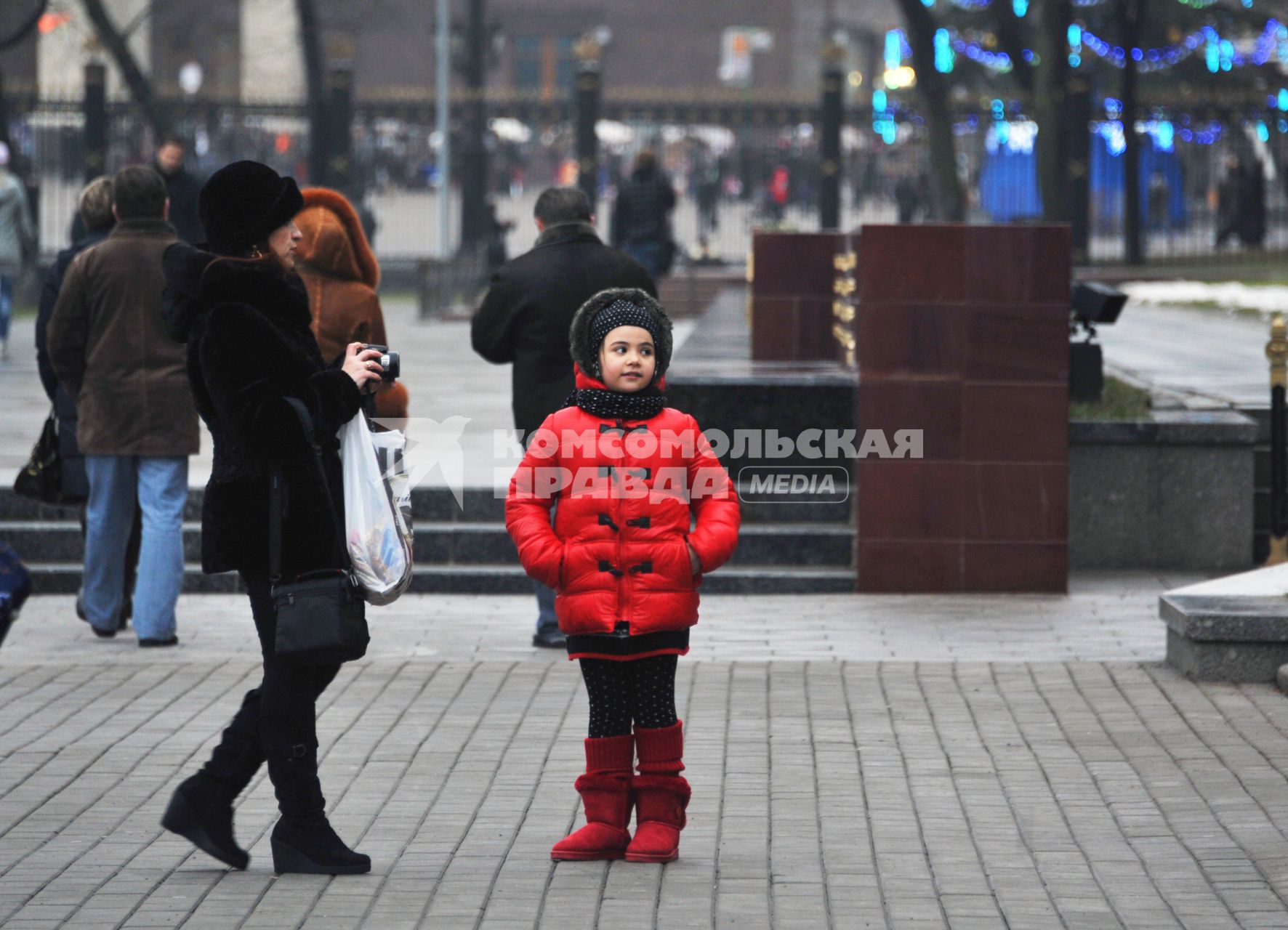 Москва центр города, люди. Мама с дочкой стоит на площади. Собирается её фотографировать. 15 Декабря 2011 года.