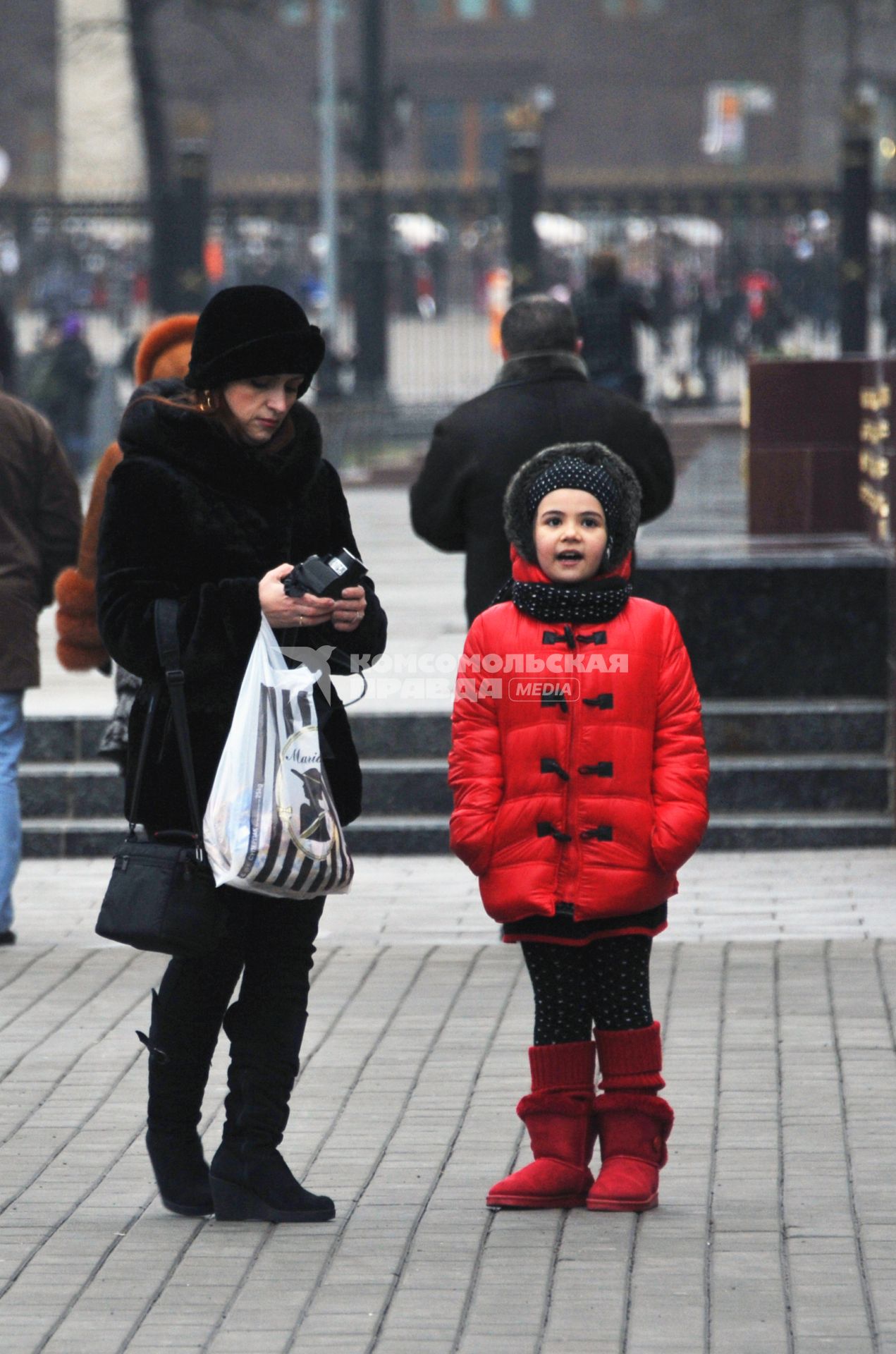 Москва центр города, люди. Мама с дочкой стоит на площади. 15 Декабря 2011 года