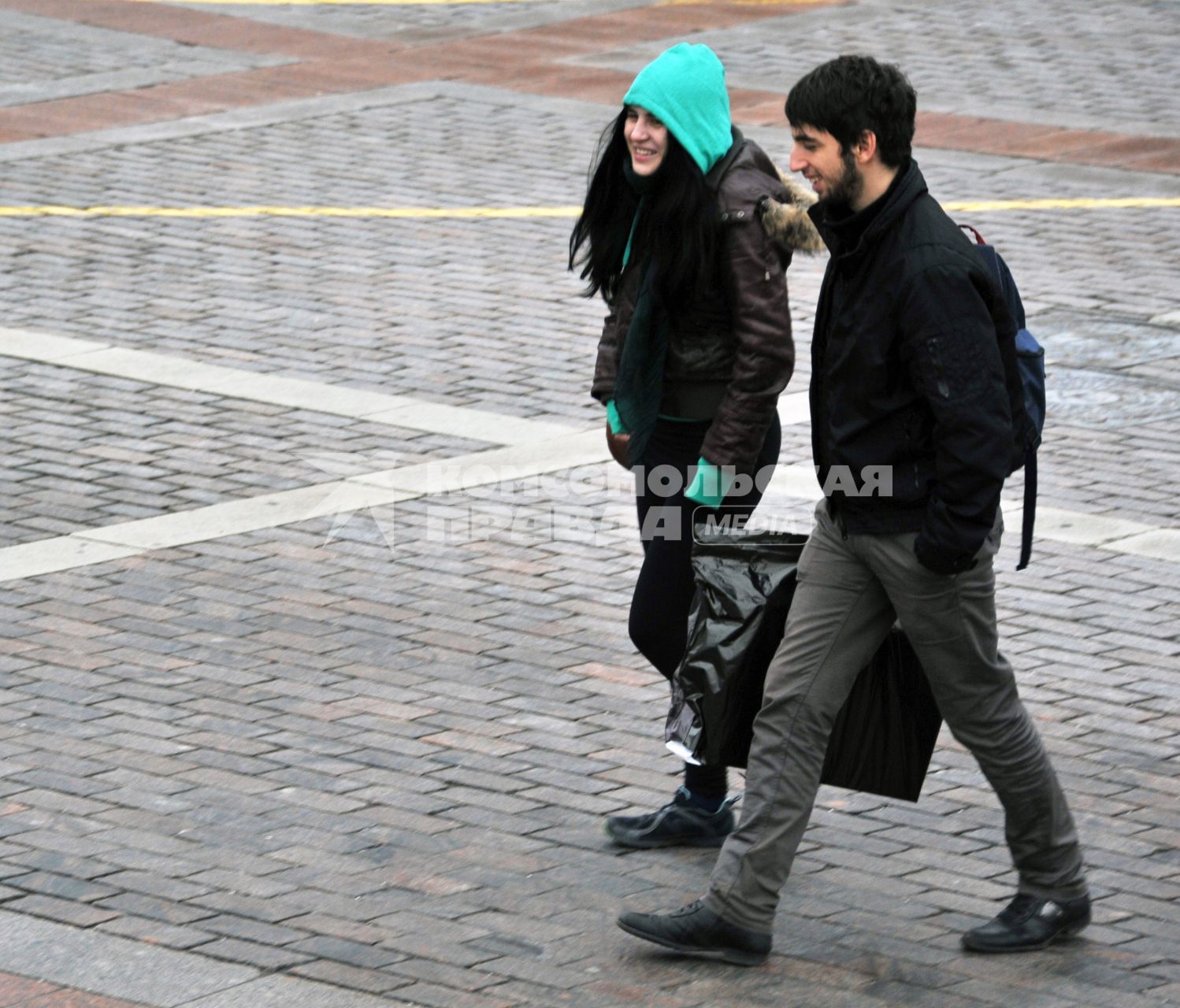 Москва центр города, люди. Молодая пара мужчина и женщина идут по площади. 15 Декабря 2011 года